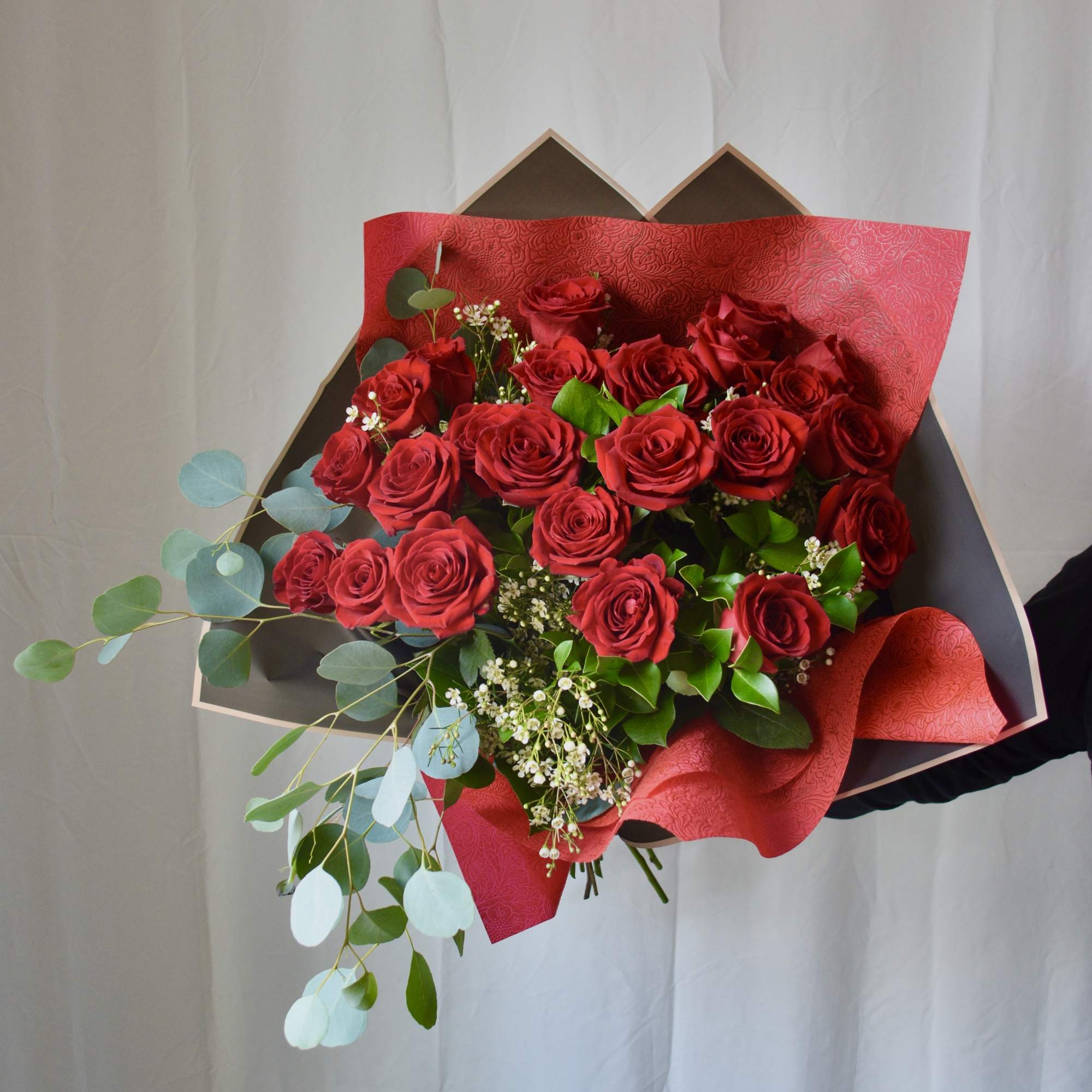 Featuring luxurious roses arranged in lush greenery, wrapped in premium paper and