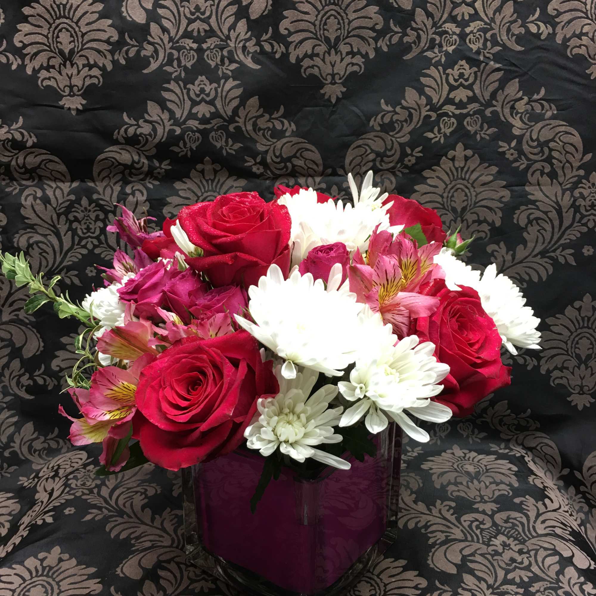 This arrangement contains spray daisies and spray roses. Soft an Gentle are