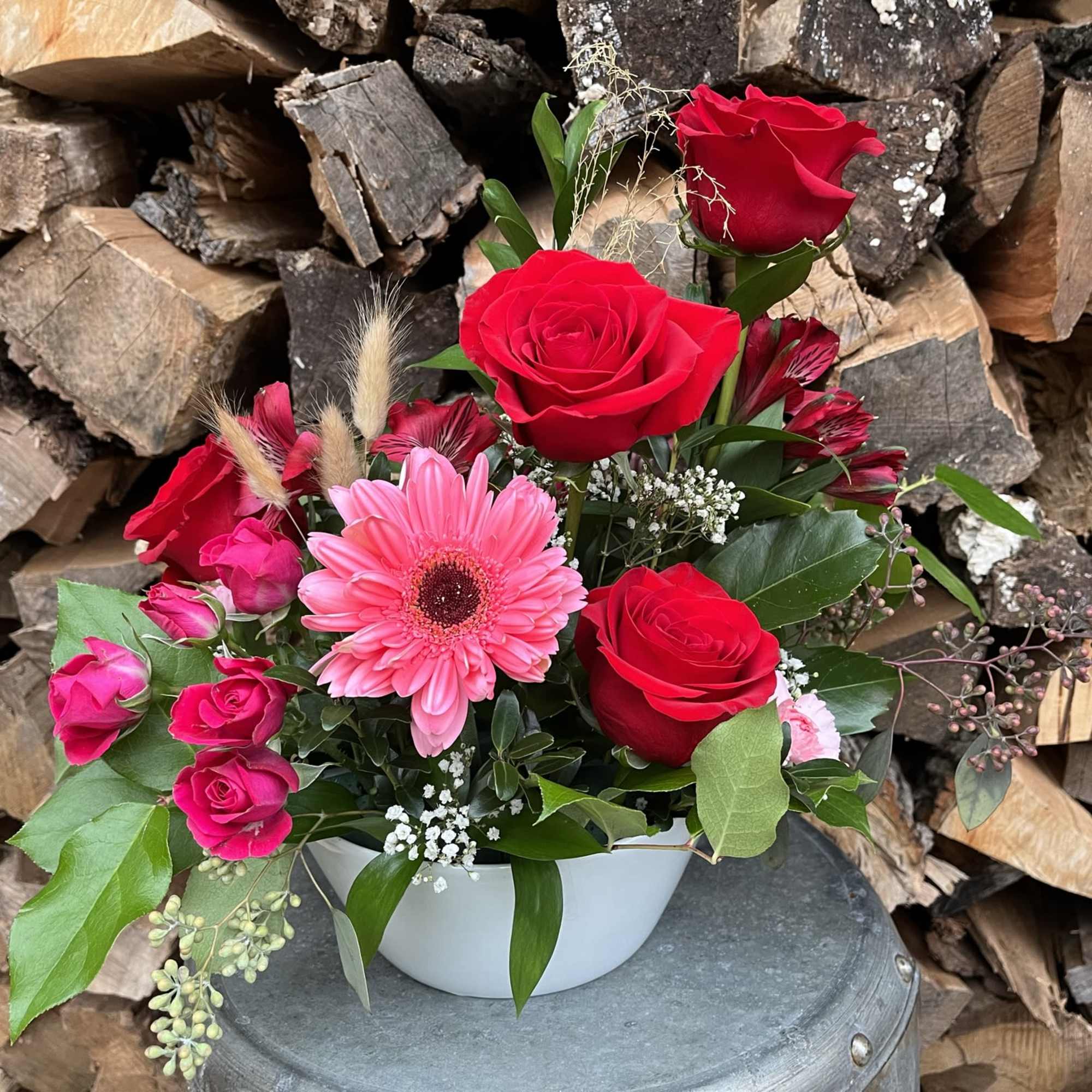 Classic red roses designed in a white bowl accented with Gerber daisies