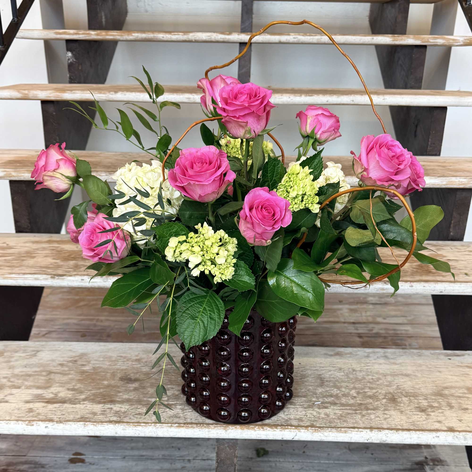 Pink Roses, green Mini Hydrangeas and lush greenery with curly willow accents.