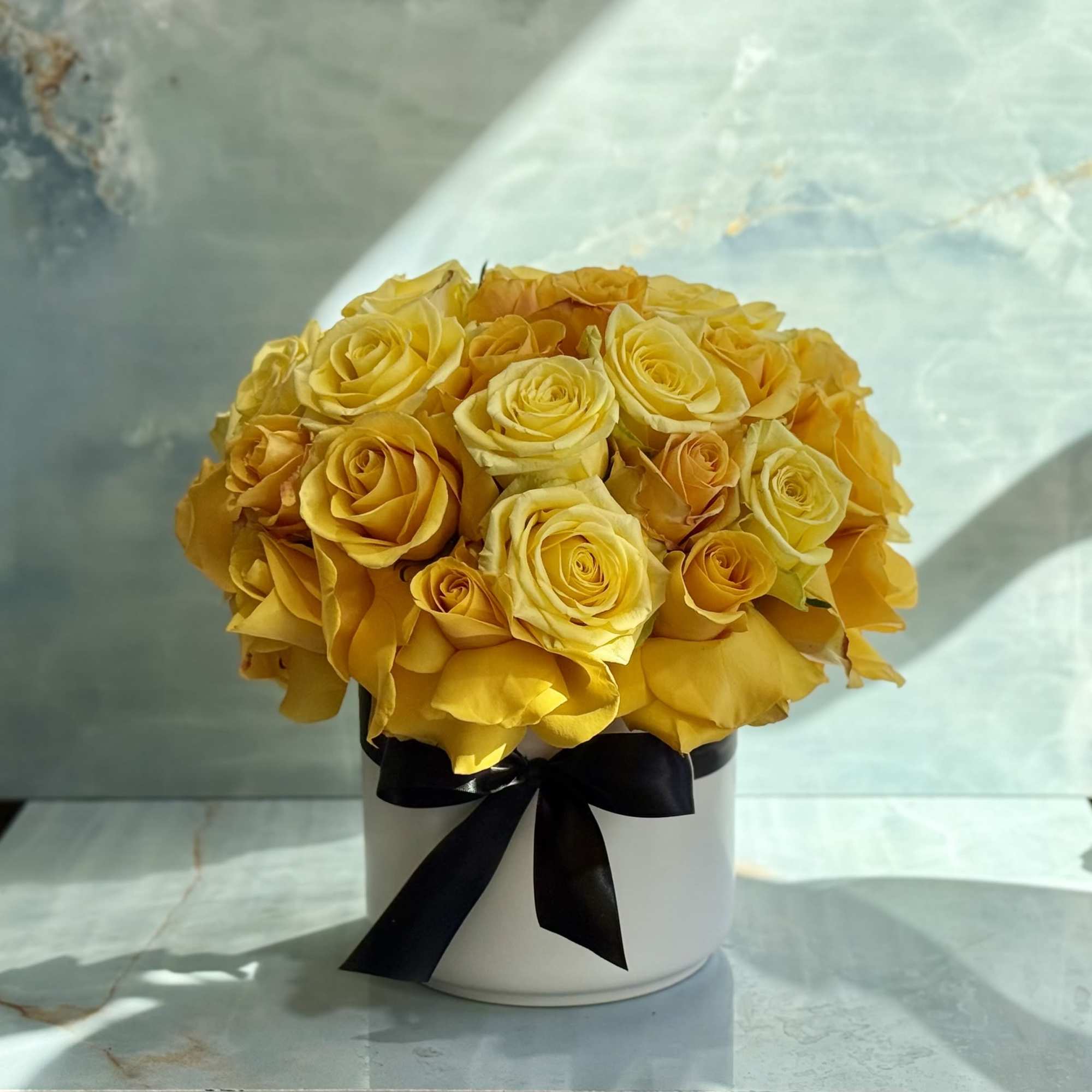 This is a luxurious yellow rose arrangement designed in a clean, modern