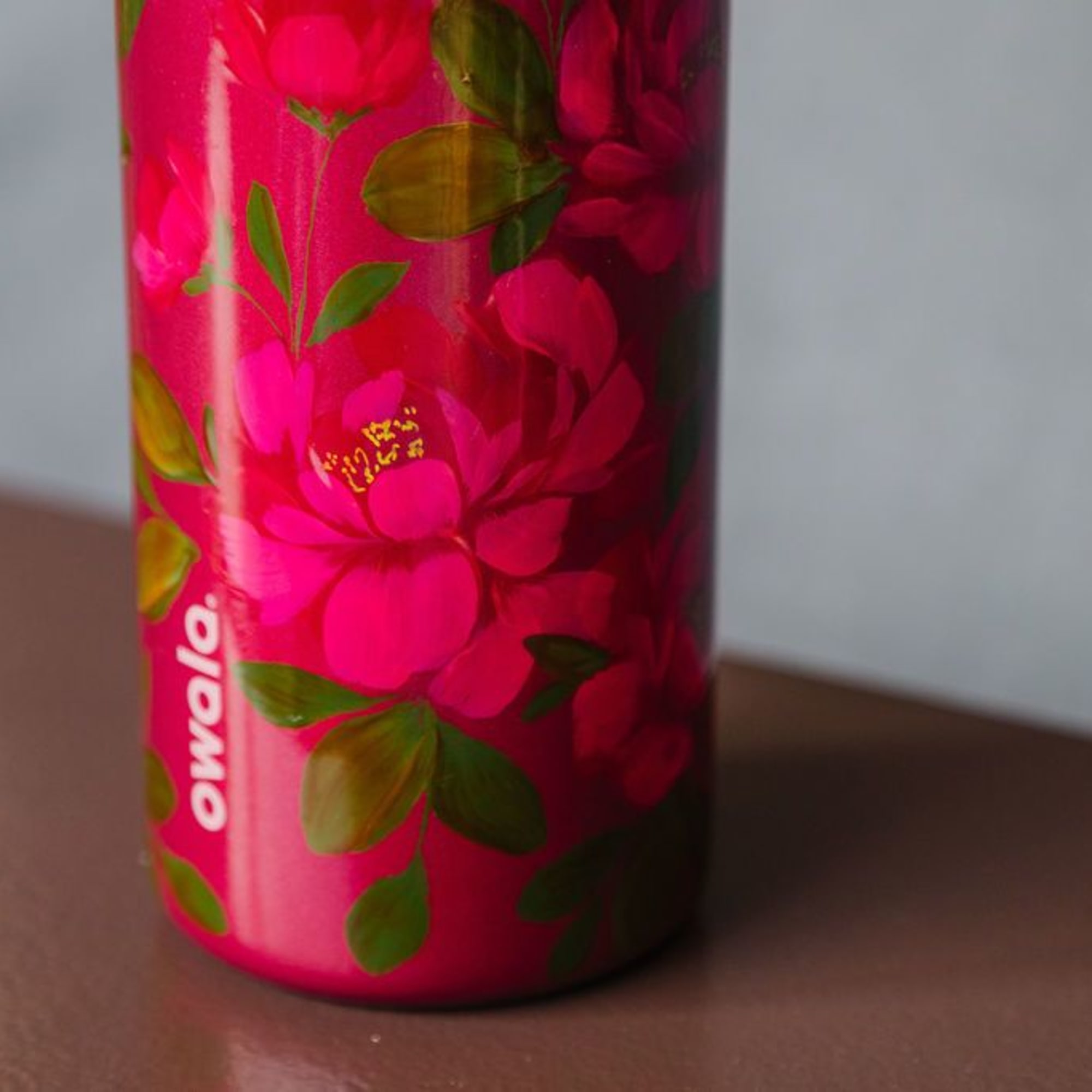 Six velvety red roses rise from lush, textural greens, styled inside a