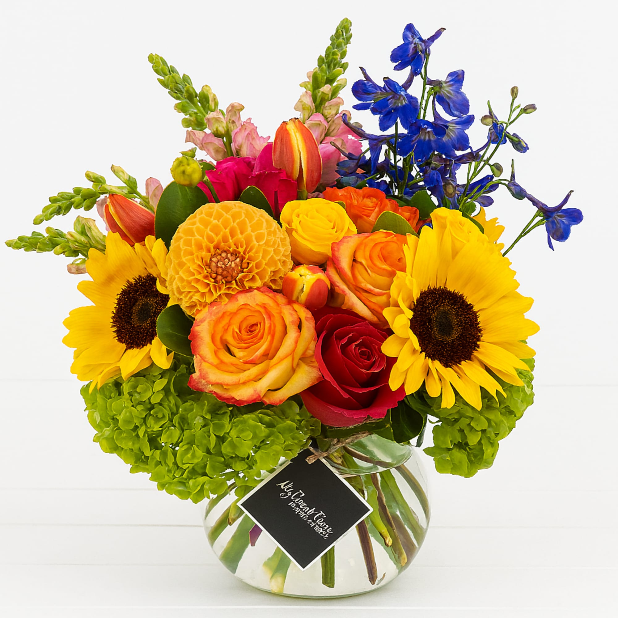 Bring joy and warmth into any space with our Colorburst Bloom arrangement