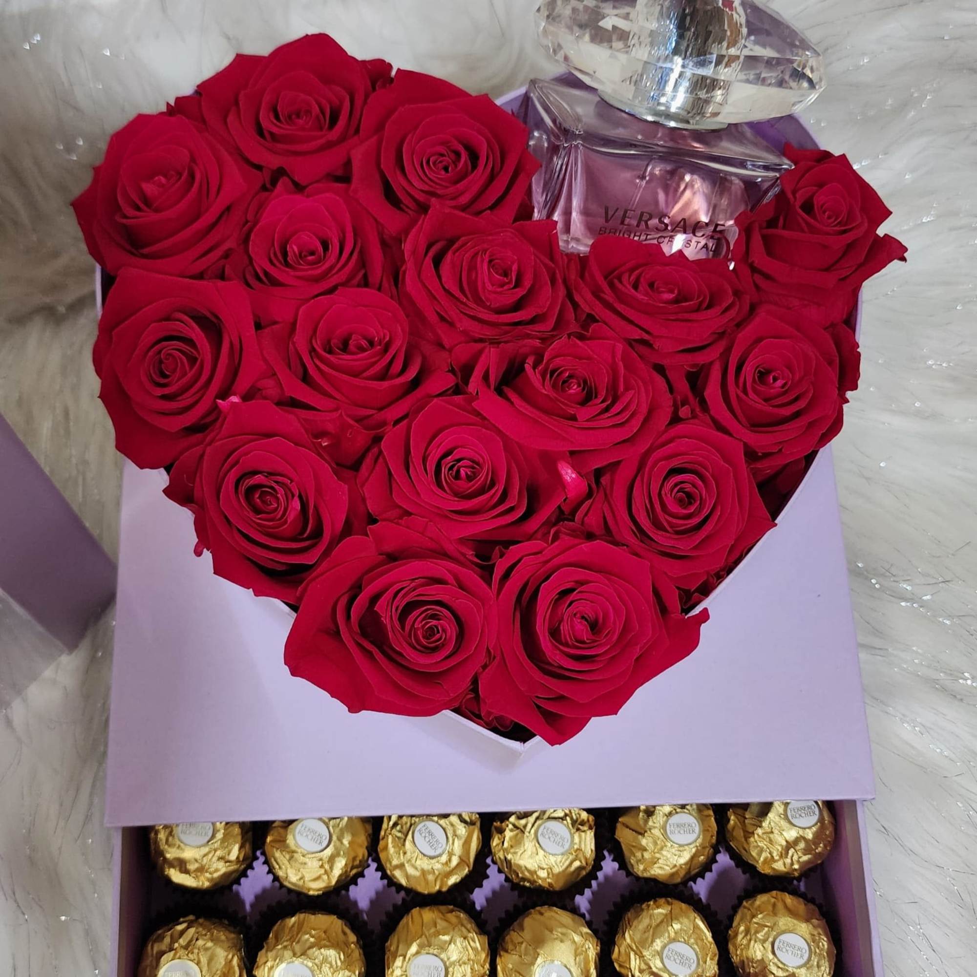 Fresh natural red roses in a heart shaped box that includes chocolates