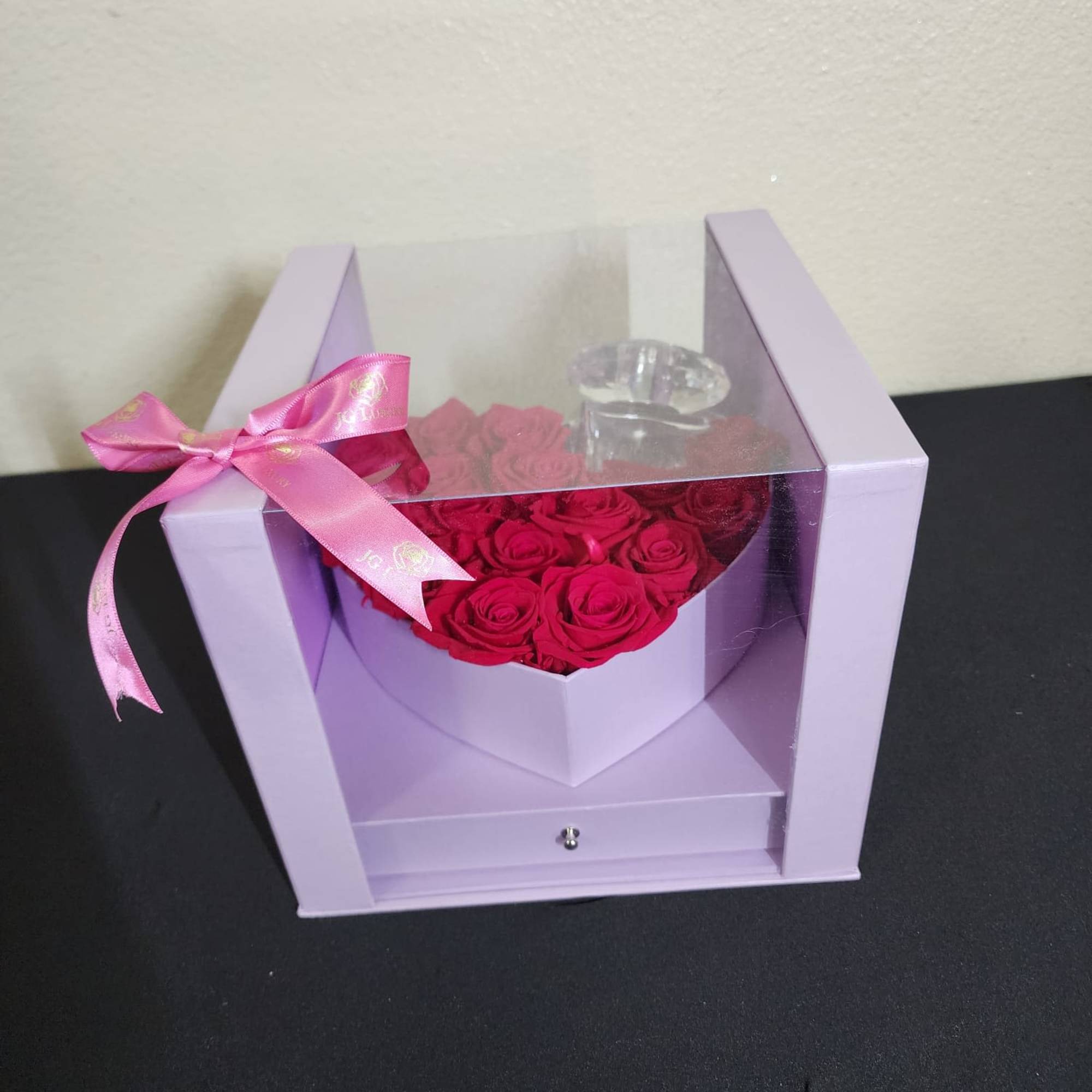 Fresh natural red roses in a heart shaped box that includes chocolates