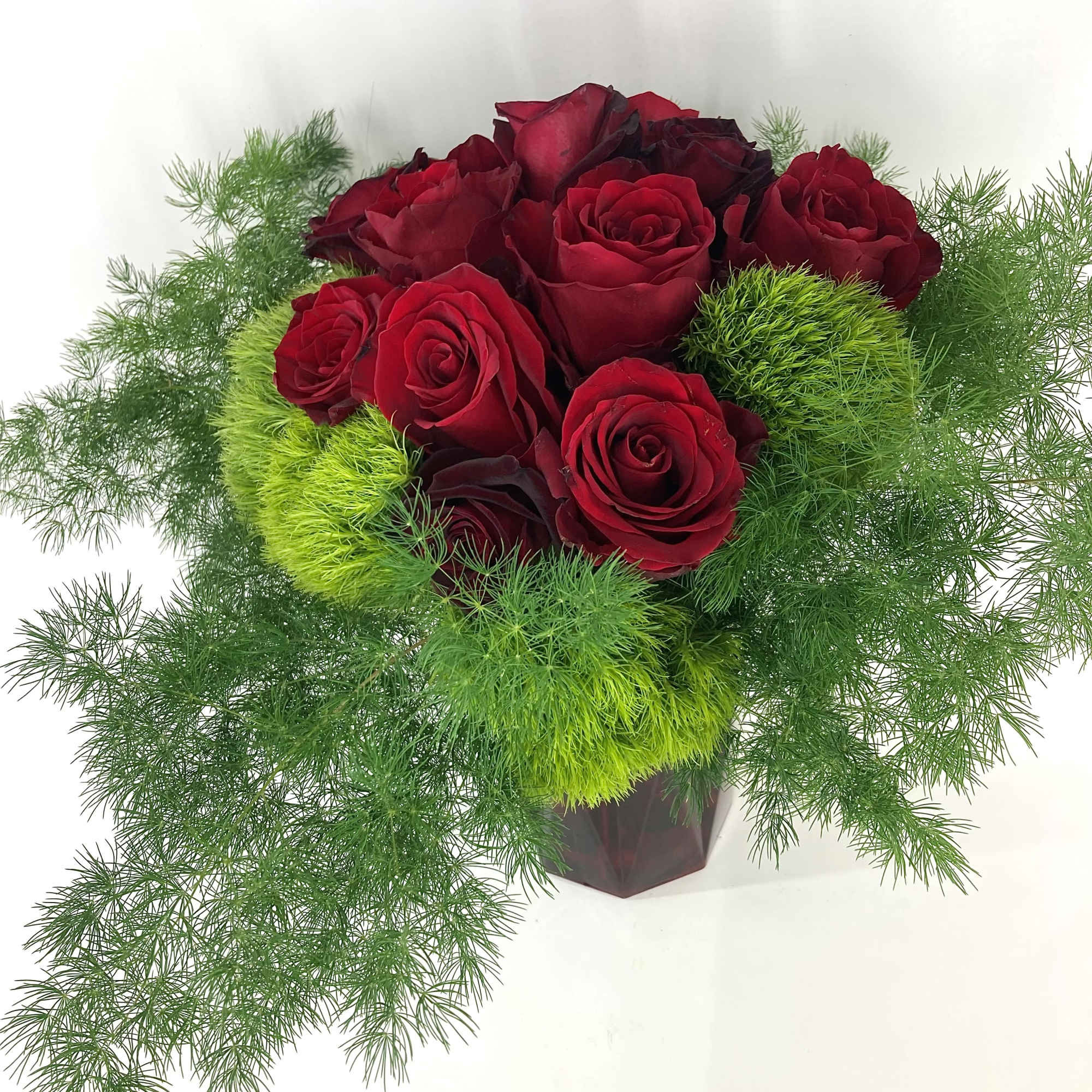 A beautifully designed white cut glass vase filled with a mixture of