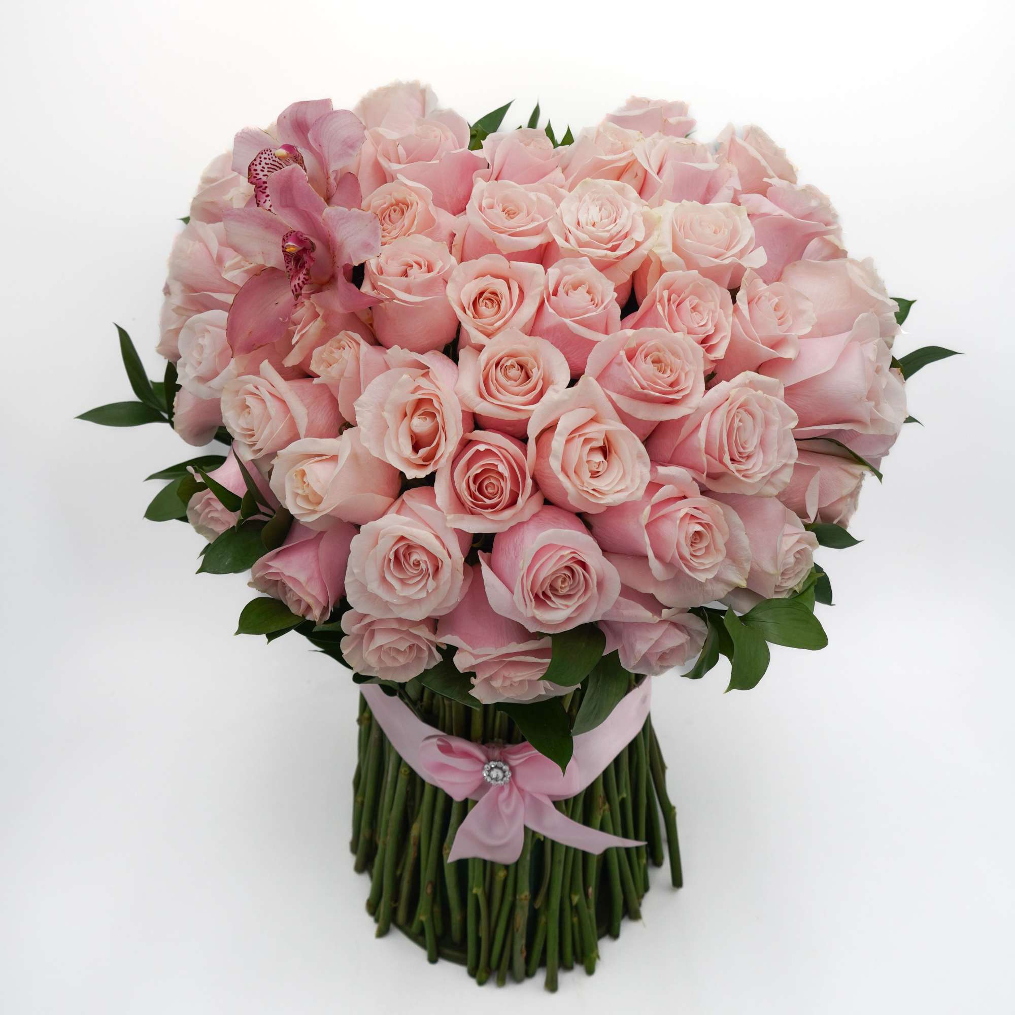 An arrangement of pink roses with a soft orchid accents, finished with