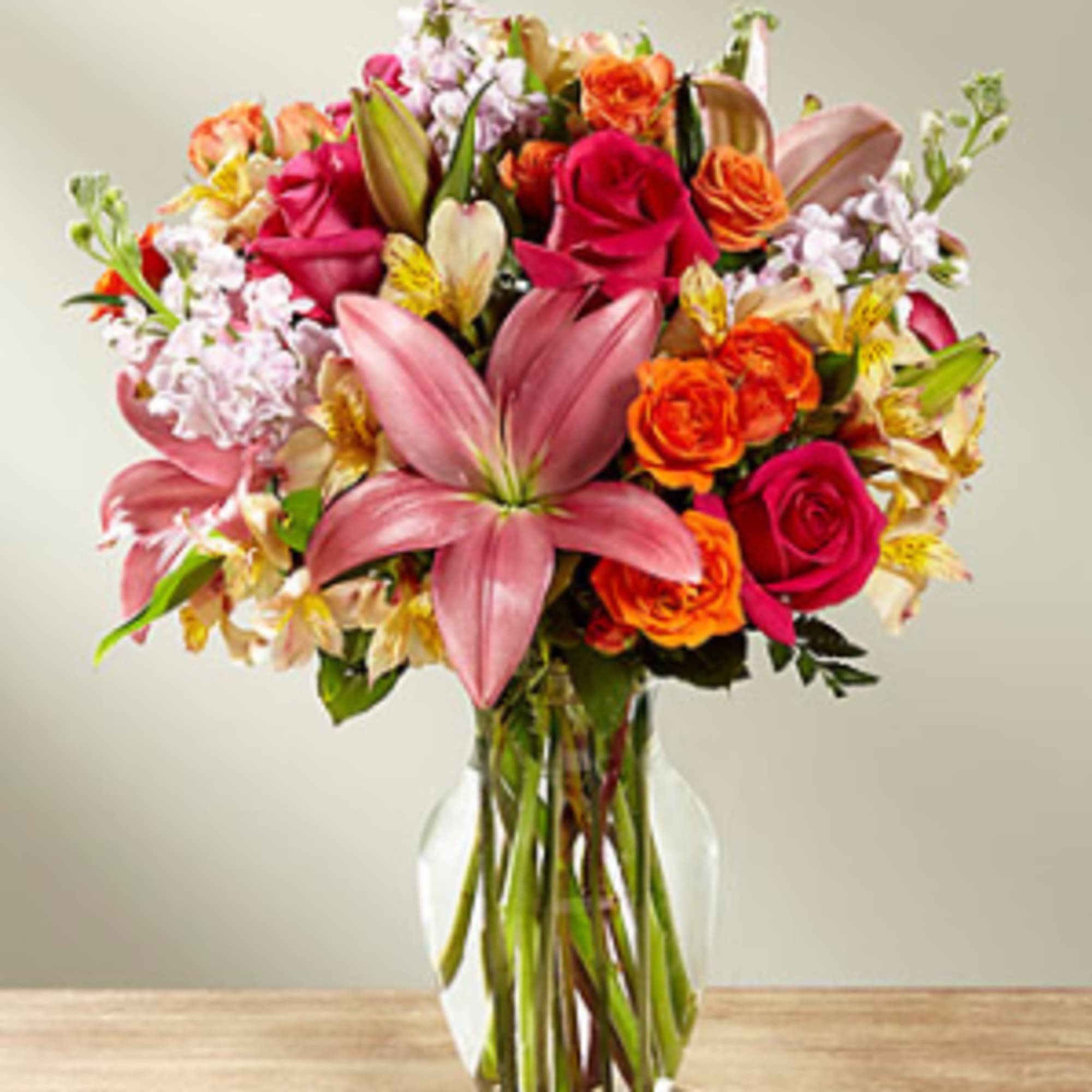 Hot pink roses, orange spray roses, pink gilly flower, and pink Asiatic