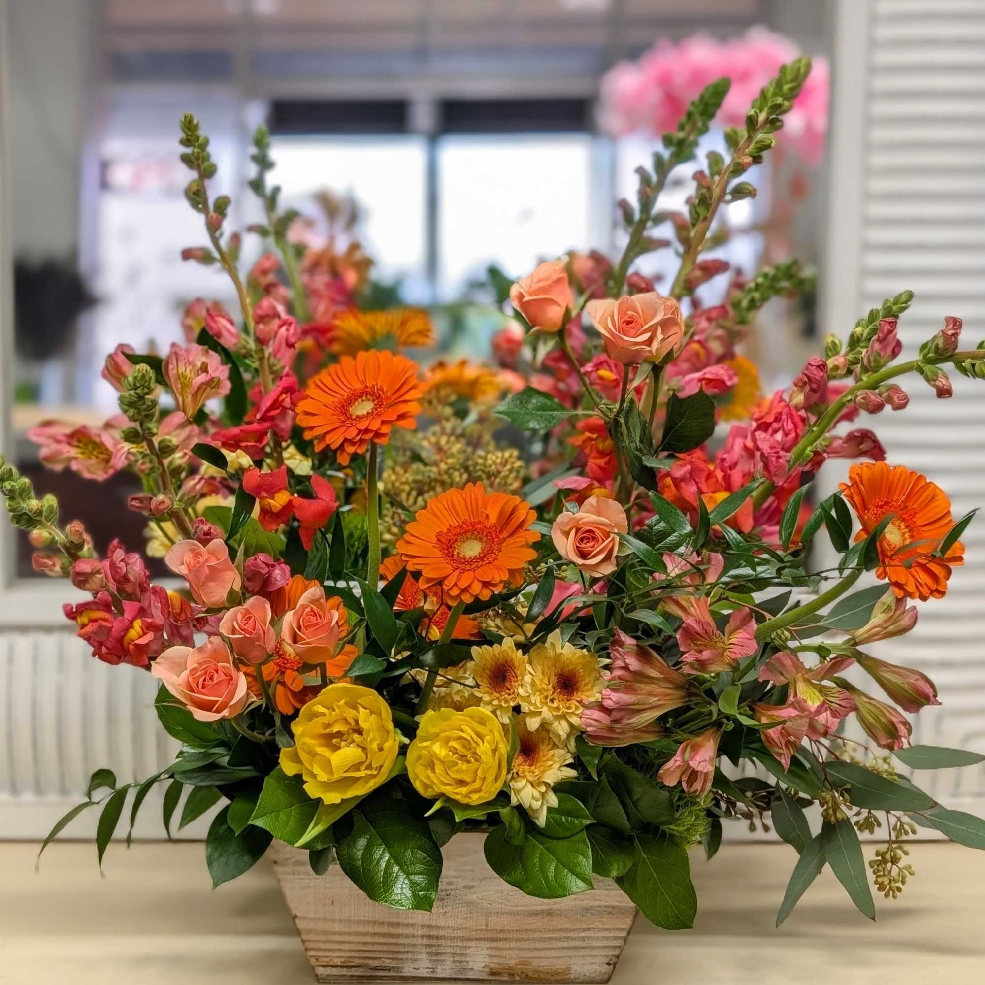 A display of citrus tones of spring flowers design in a rustic