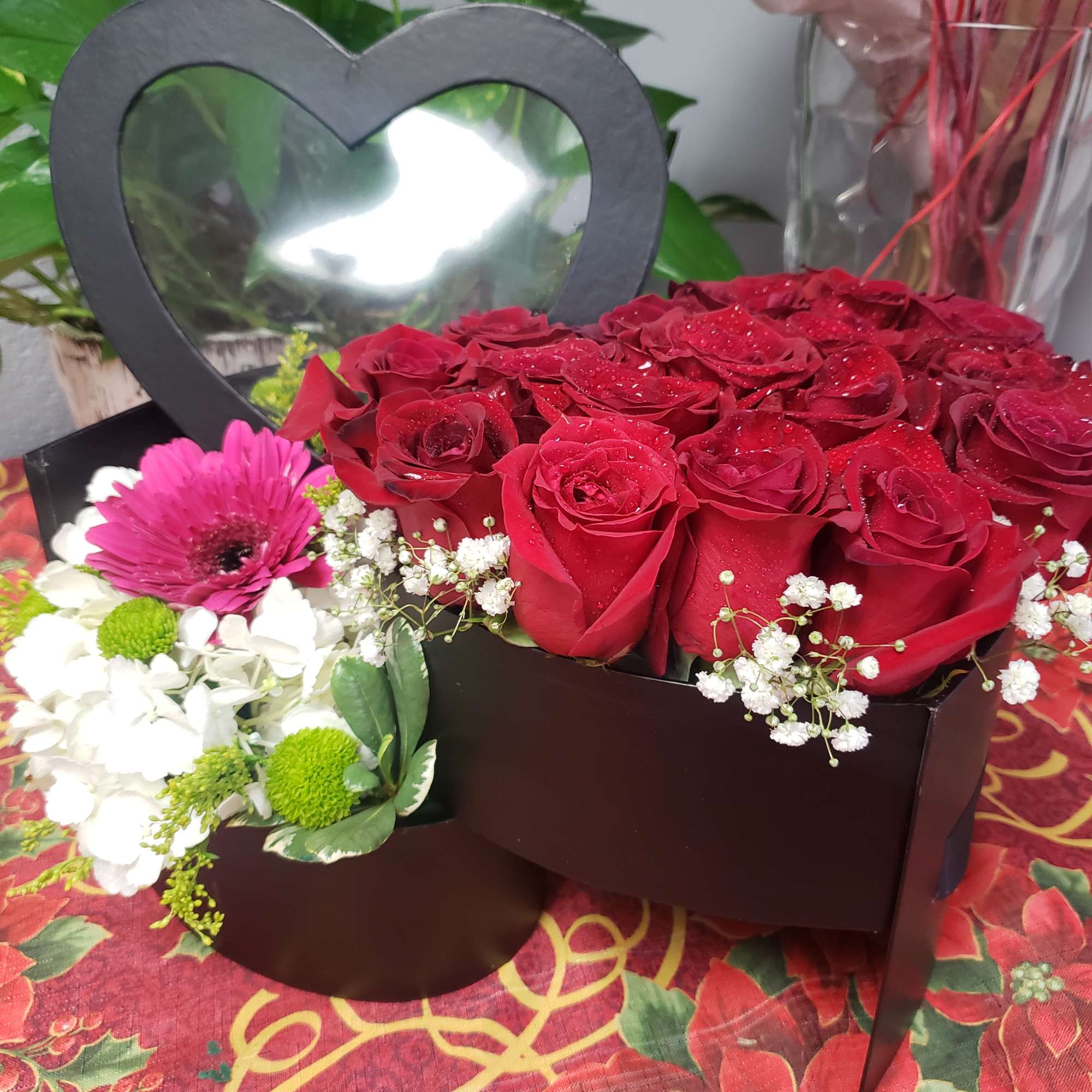  Two heart-shaped floral arrangements  
with spring flowers and red roses.