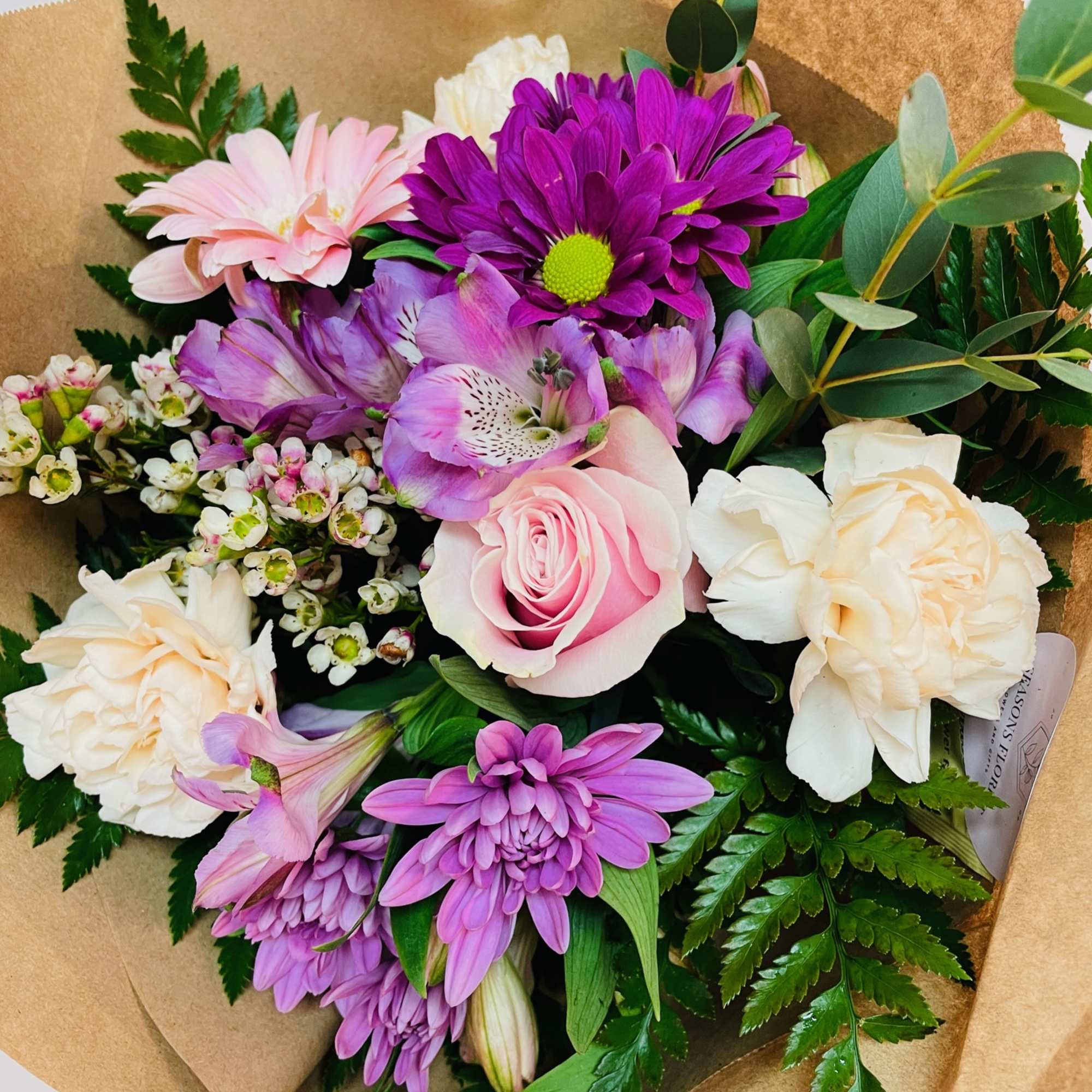 A selection of pastel flowers. This bouquet comes wrapped in paper, ready