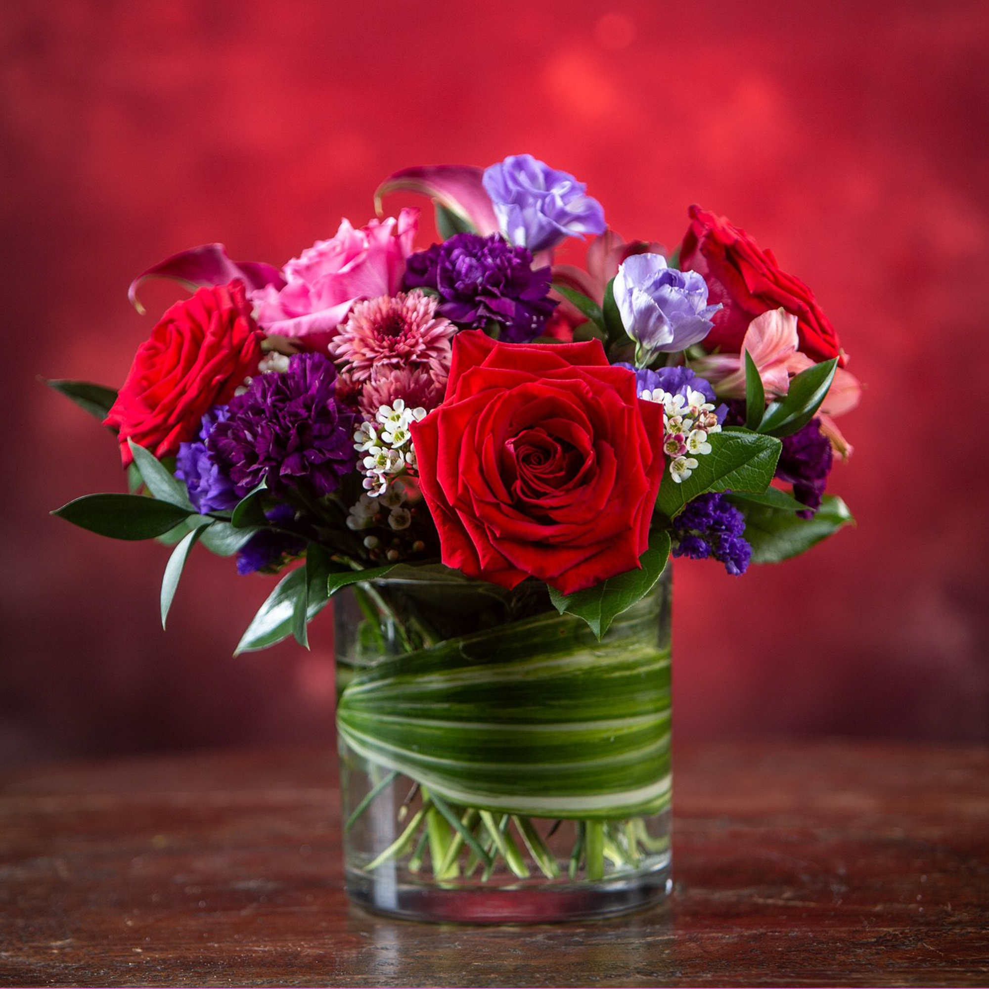 A rich display of our favorite calla lilies, roses with purple accents