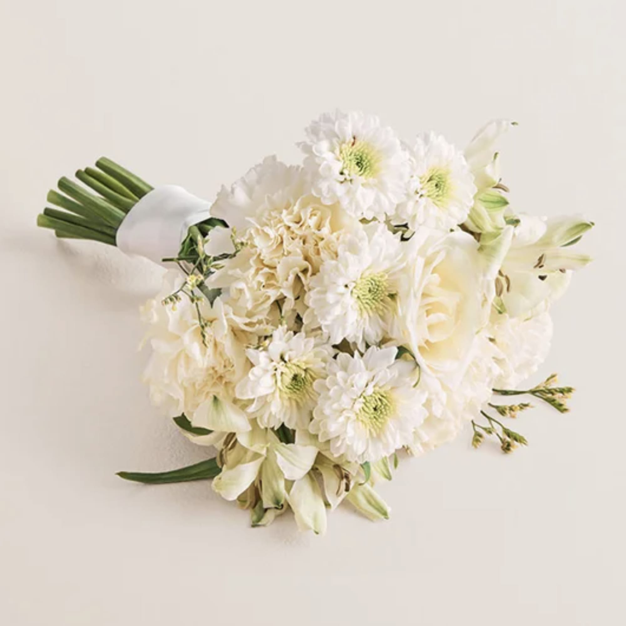 Standard:bouquet features a white rose and white Peruvian lilies (alstroemerias), carnations, button