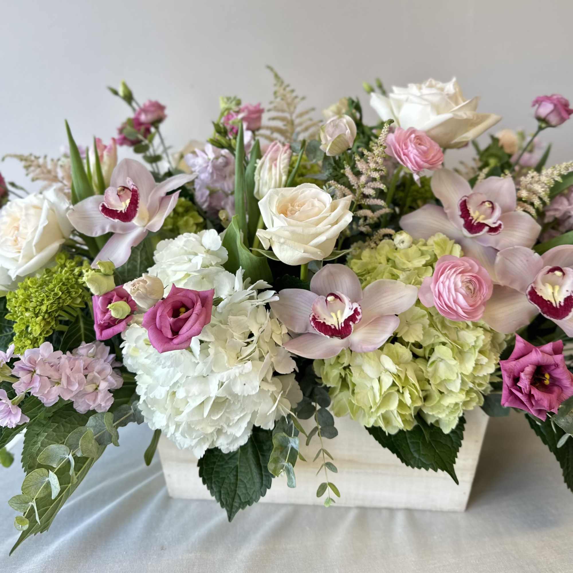 An extravagant arrangement of dazzling flowers in a large oblong planter box.