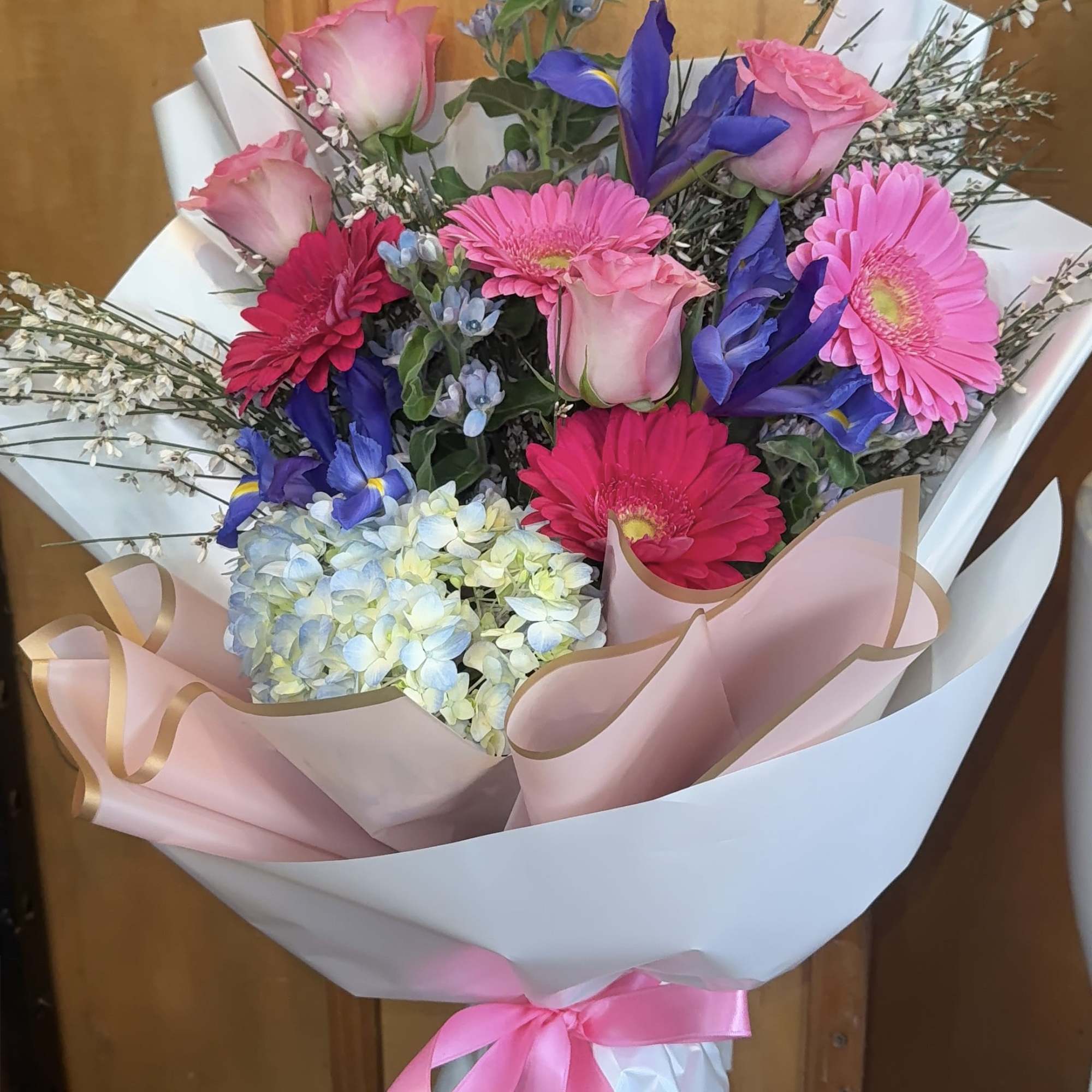 A lively and elegant hand-tied bouquet bursting with shades of pink, blush