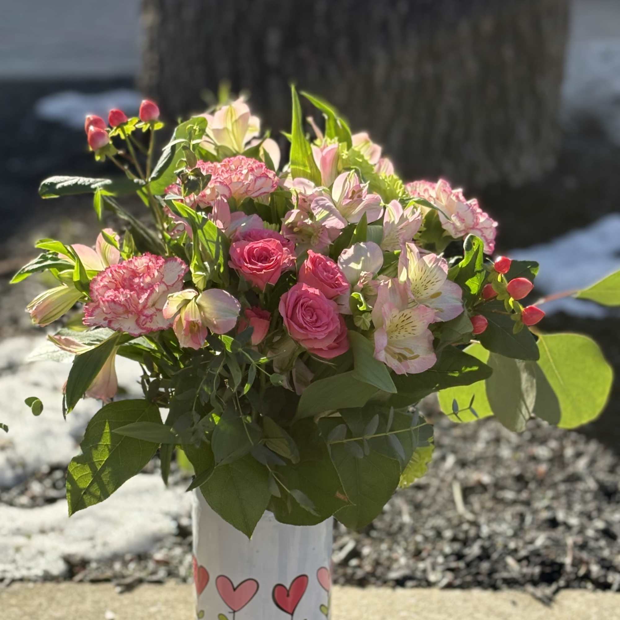 Cute white mason jar decorated with blooming hearts is filled with coordinating