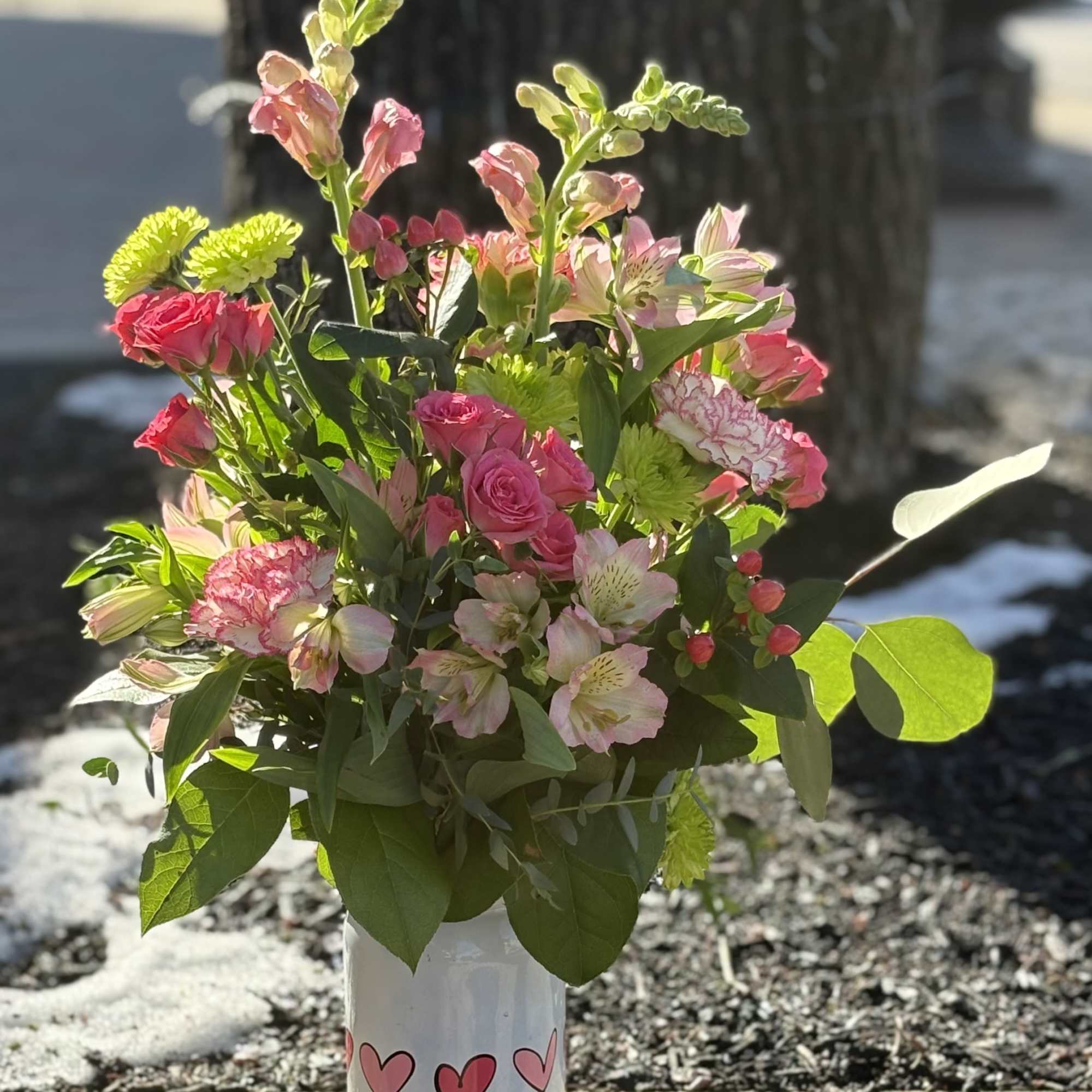 Cute white mason jar decorated with blooming hearts is filled with coordinating