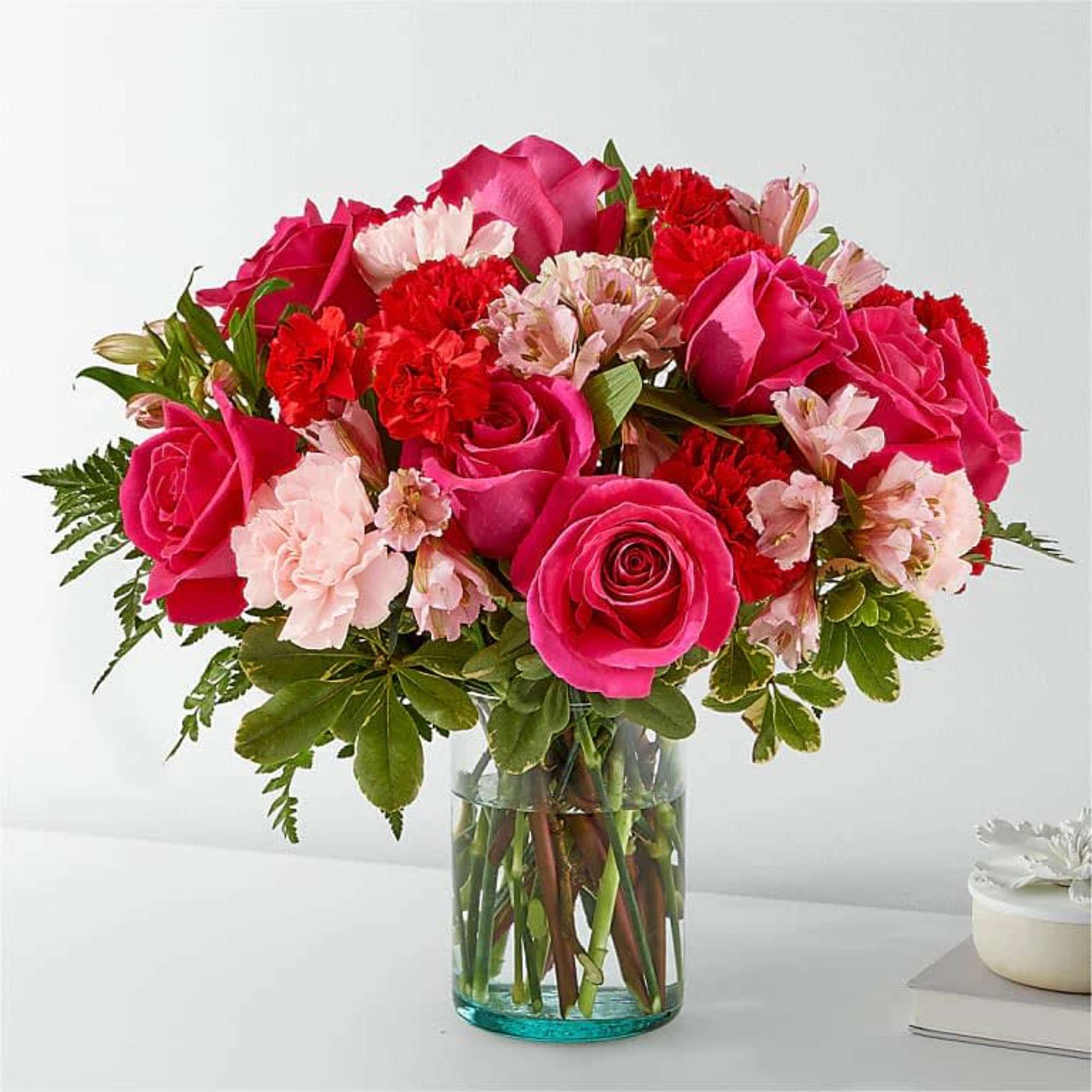 Blushing shades of pink blooms are nestled in lush greens to charm