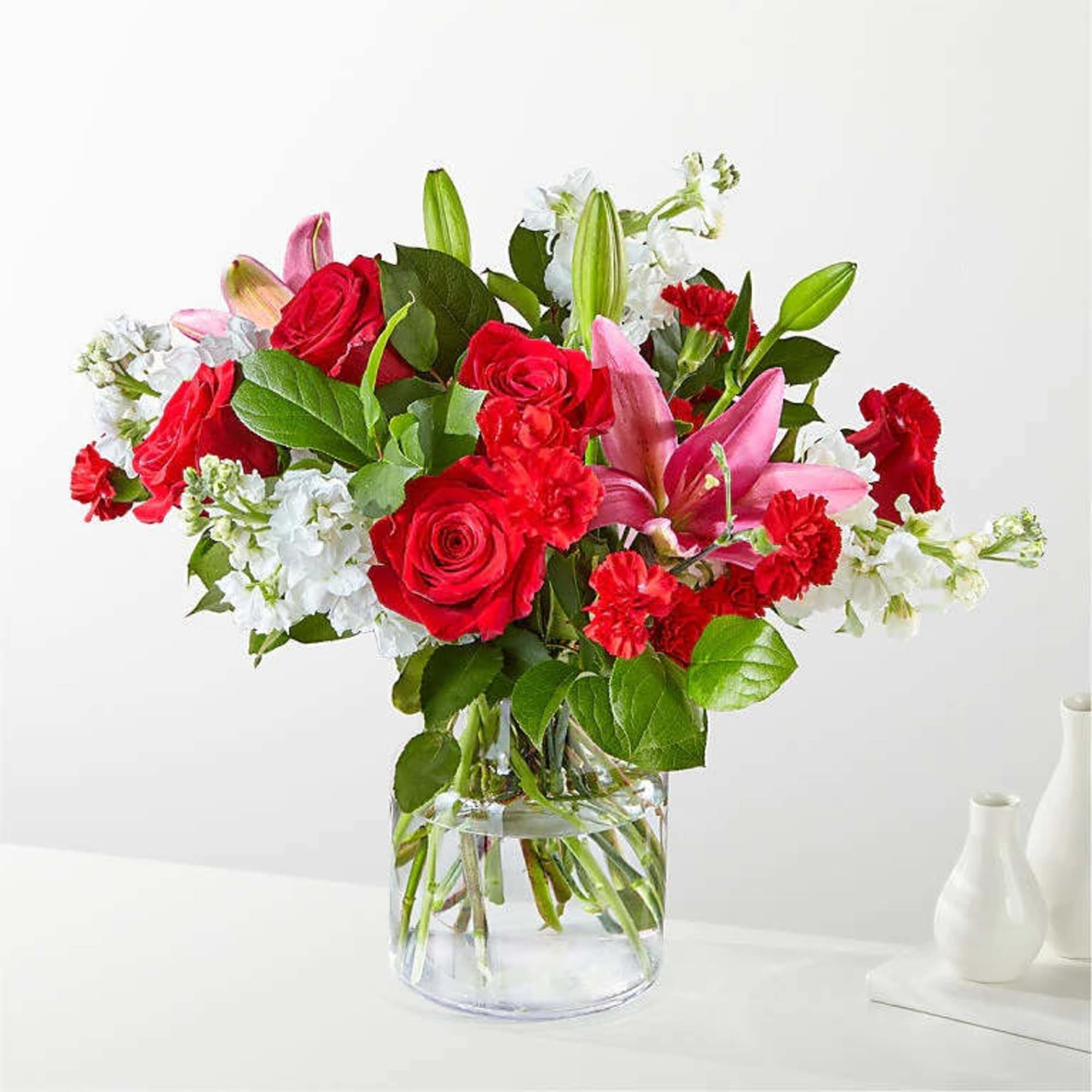With an abundant blend of roses, carnations, and LA Hybrid lilies in