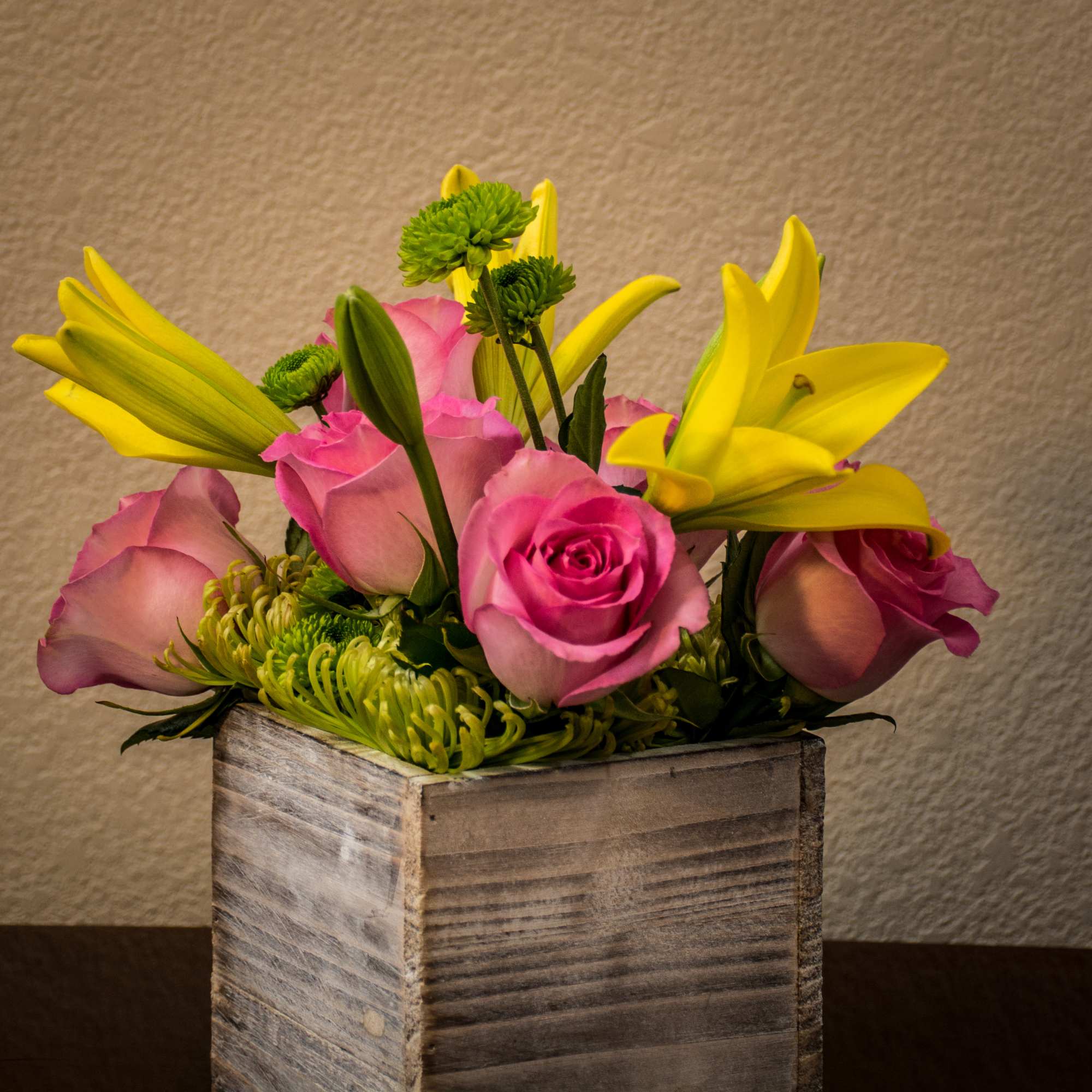 Lilies and roses on a bed of mums. Compact arrangement nice for