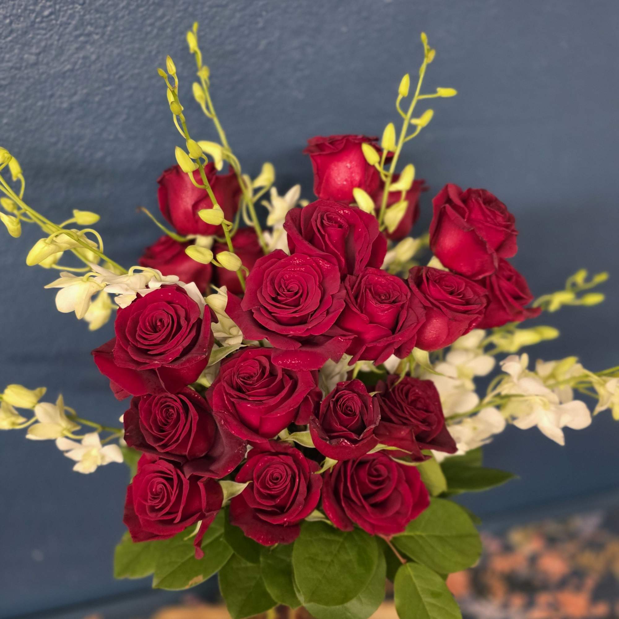 2 dozen long stem roses with beautiful white orchids. Make a statement