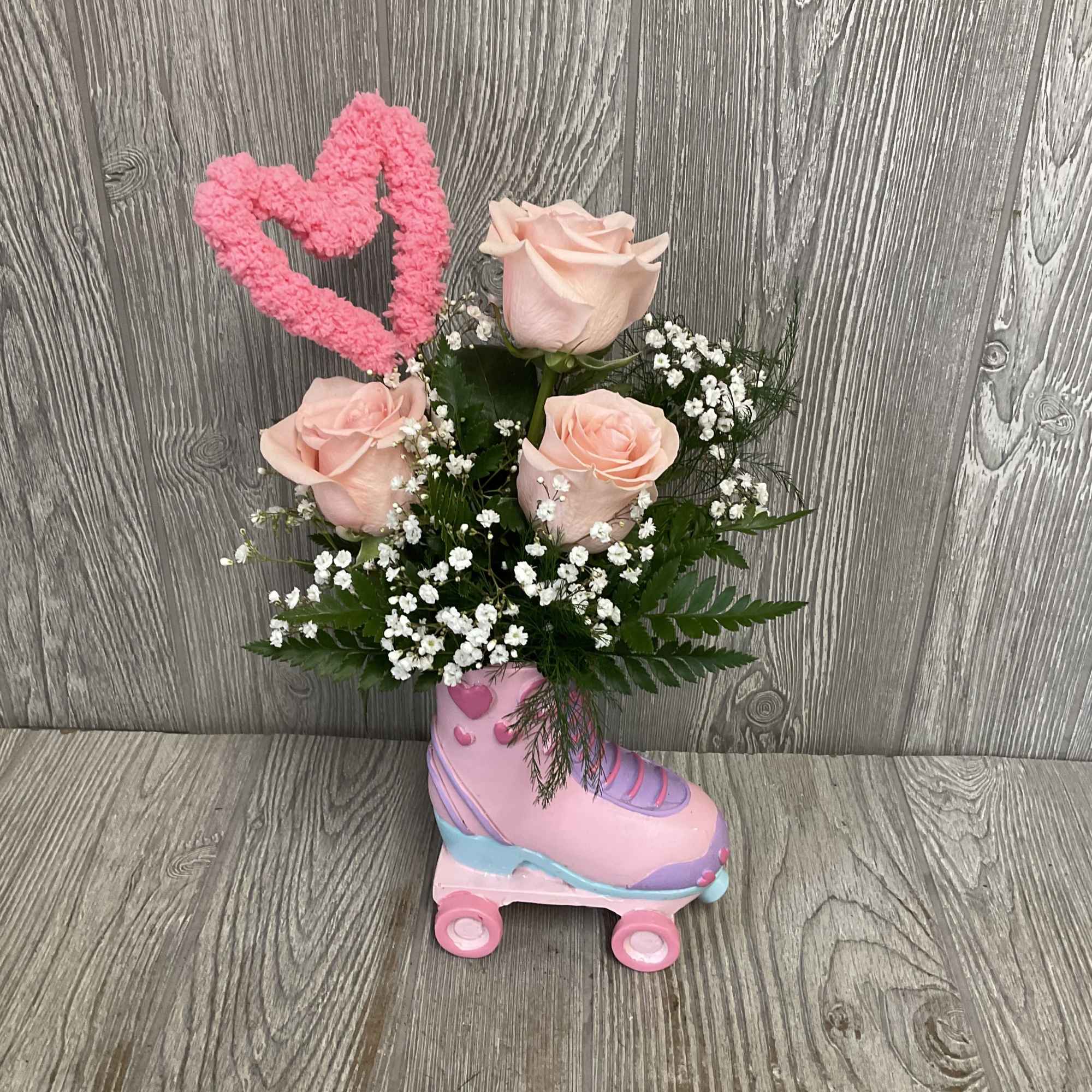 Beautiful light pink roses arranged in a retro keepsake ceramic roller skate