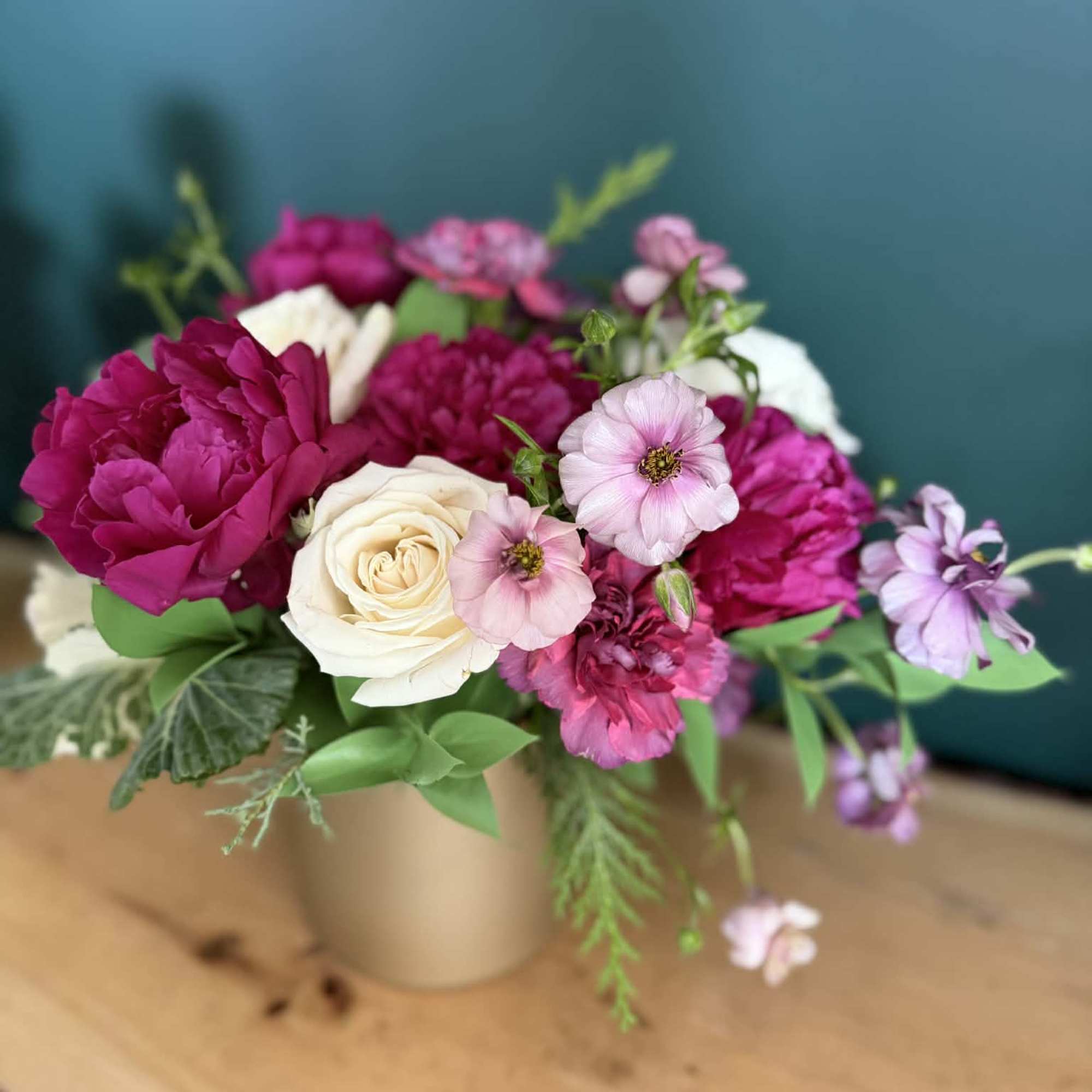 A lush, romantic arrangement featuring rich raspberry and soft blush blooms, thoughtfully