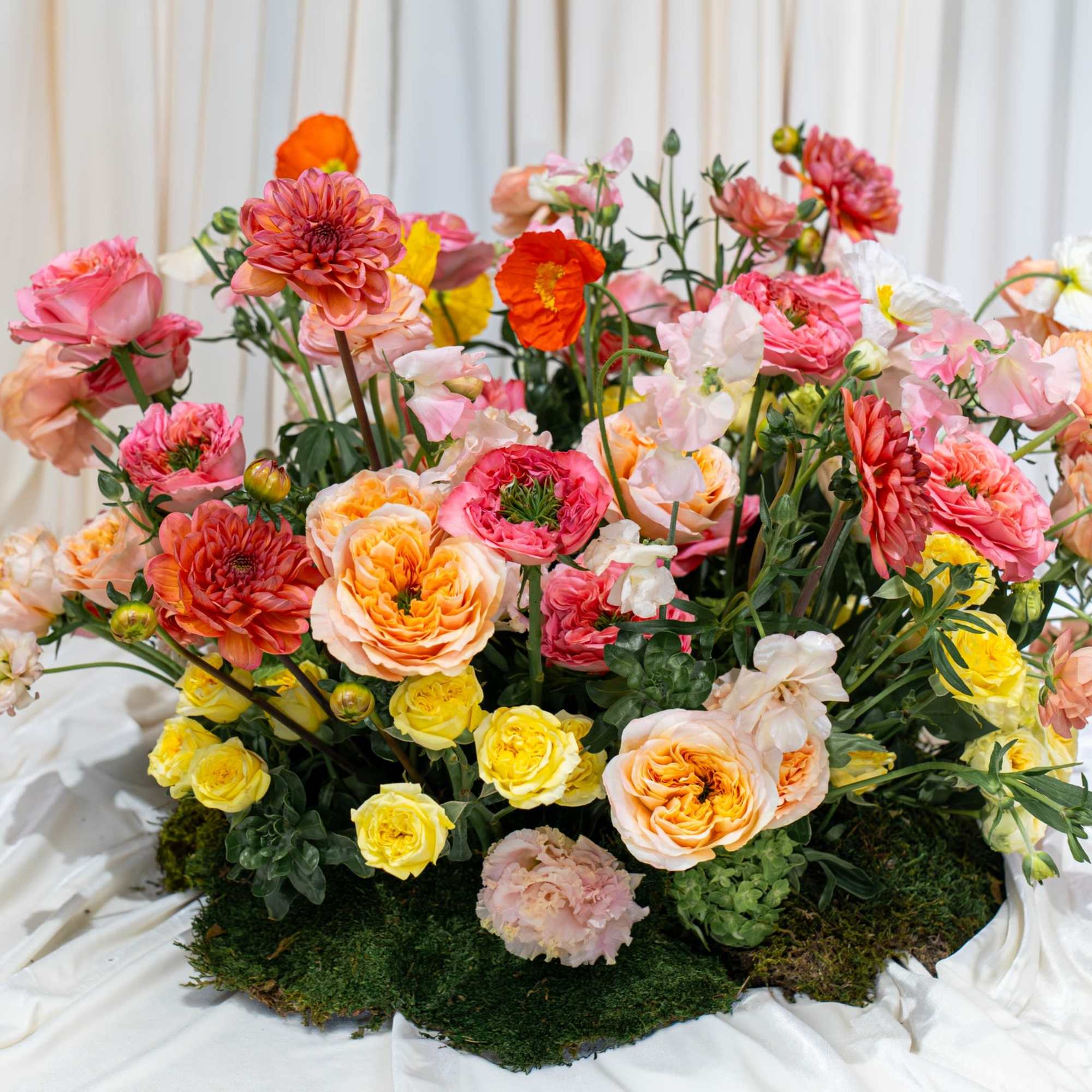 A luxury garden arrangement with moss on the base, and hanging amaranthus