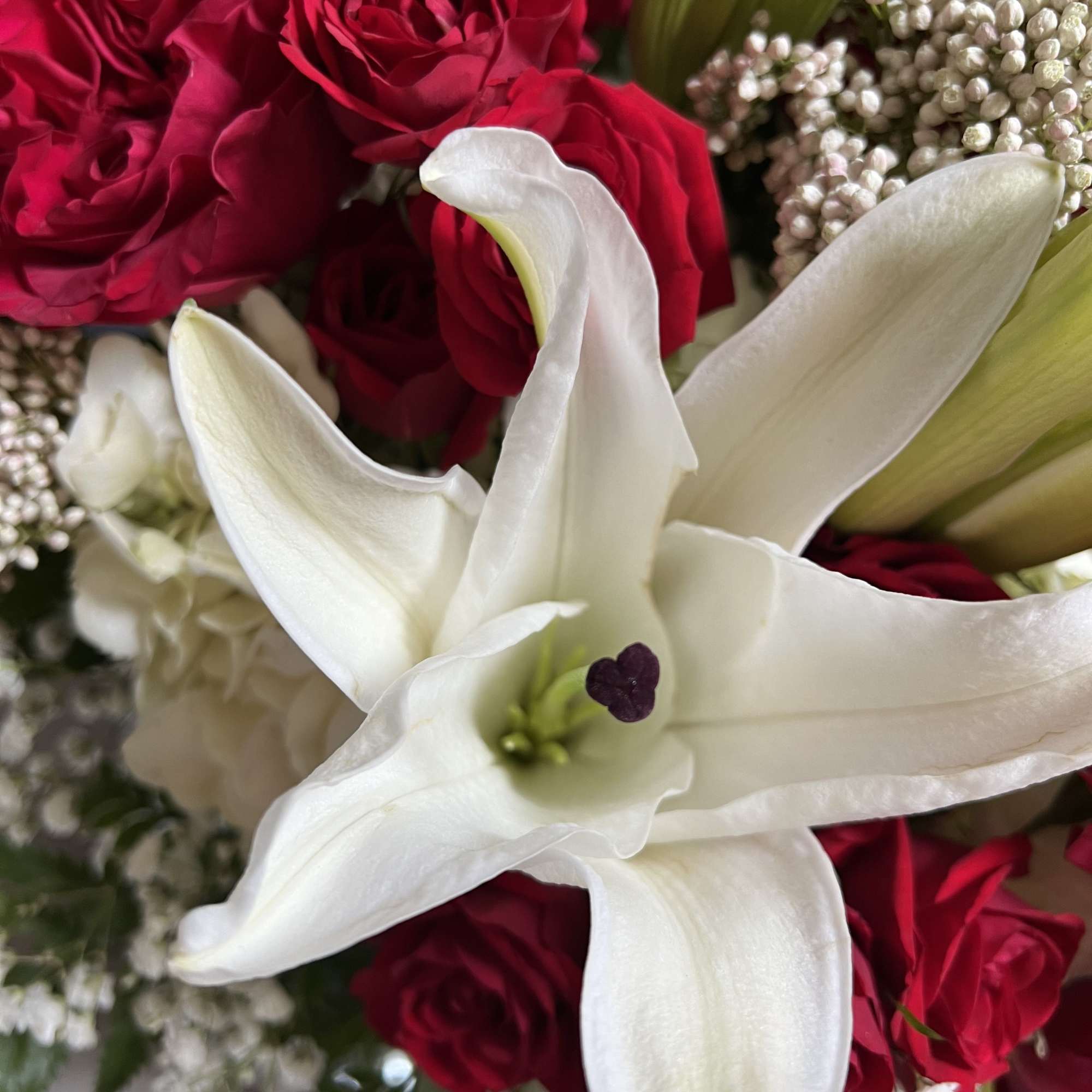 A stunning arrangement of white lilies paired with vibrant red roses, elegant