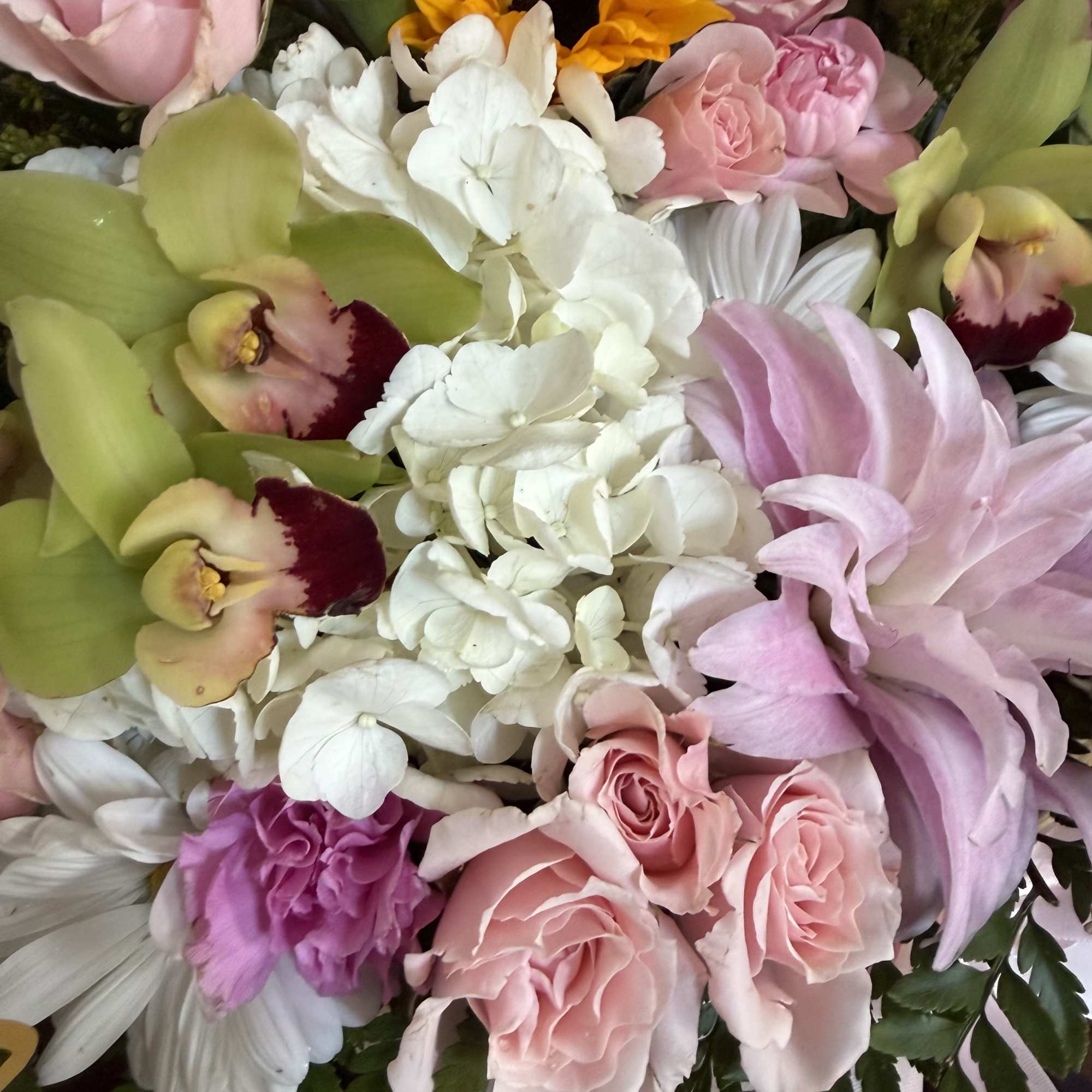 An enchanting garden-style luxury basket overflowing with delicate blush and pastel blooms