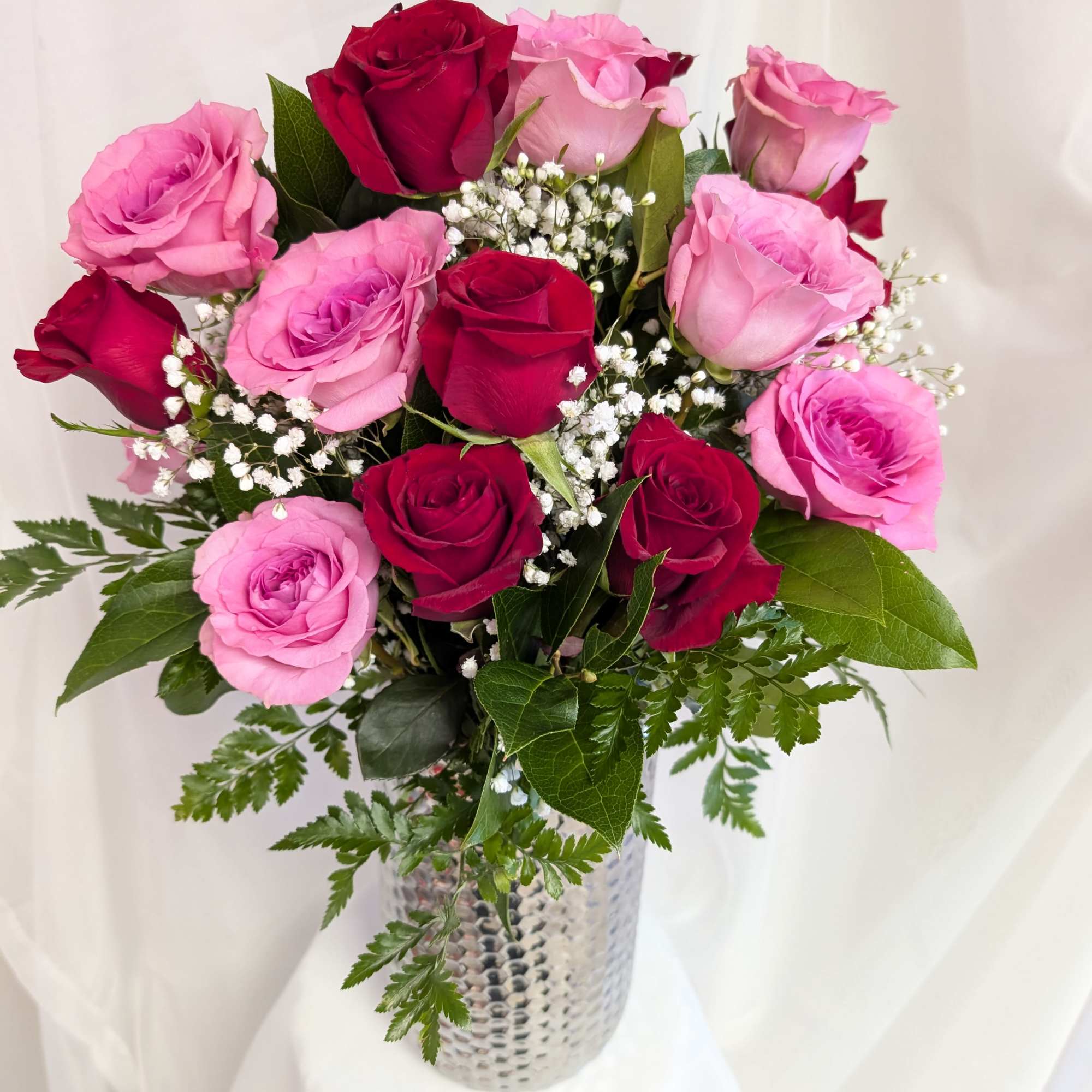 Combination of long-stem red and bright pink roses complimented by baby's breath