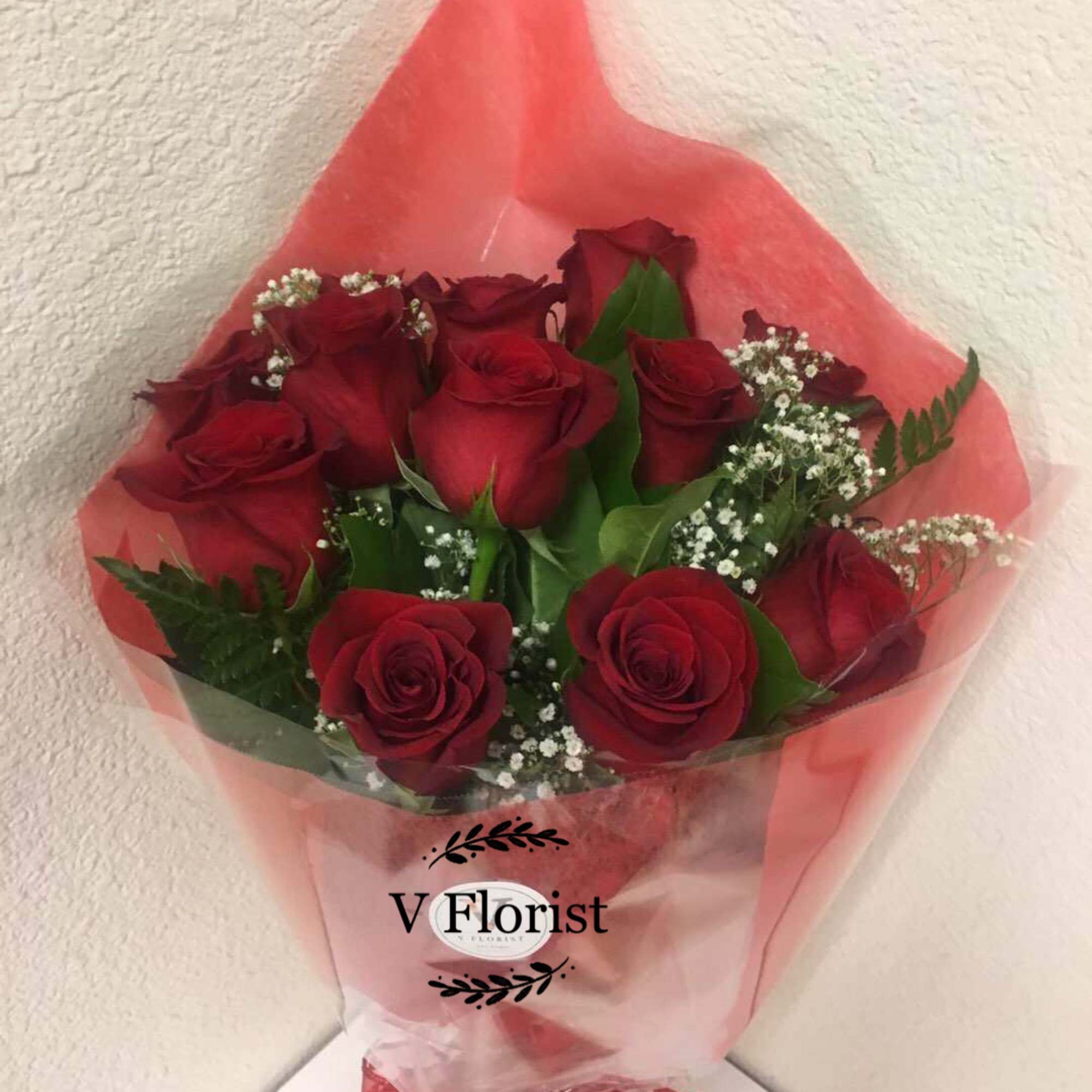 12 red roses wrapped in a hand-hold bouquet with babies' breathe and