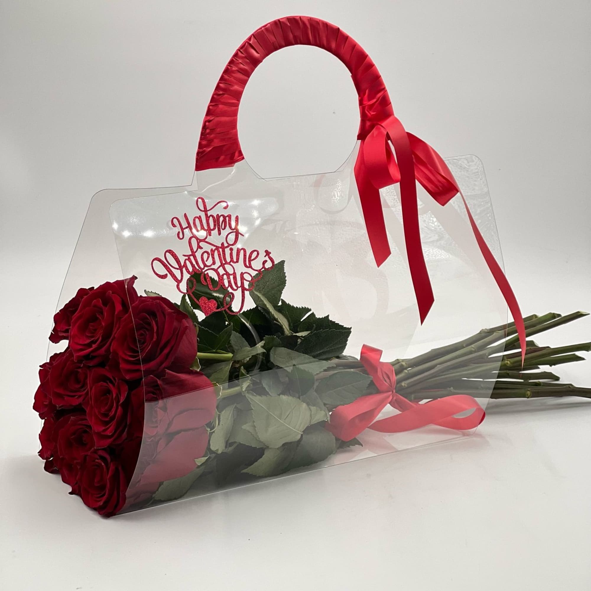 An elegand bouquet of vibrant red roses designed in a clear plastic