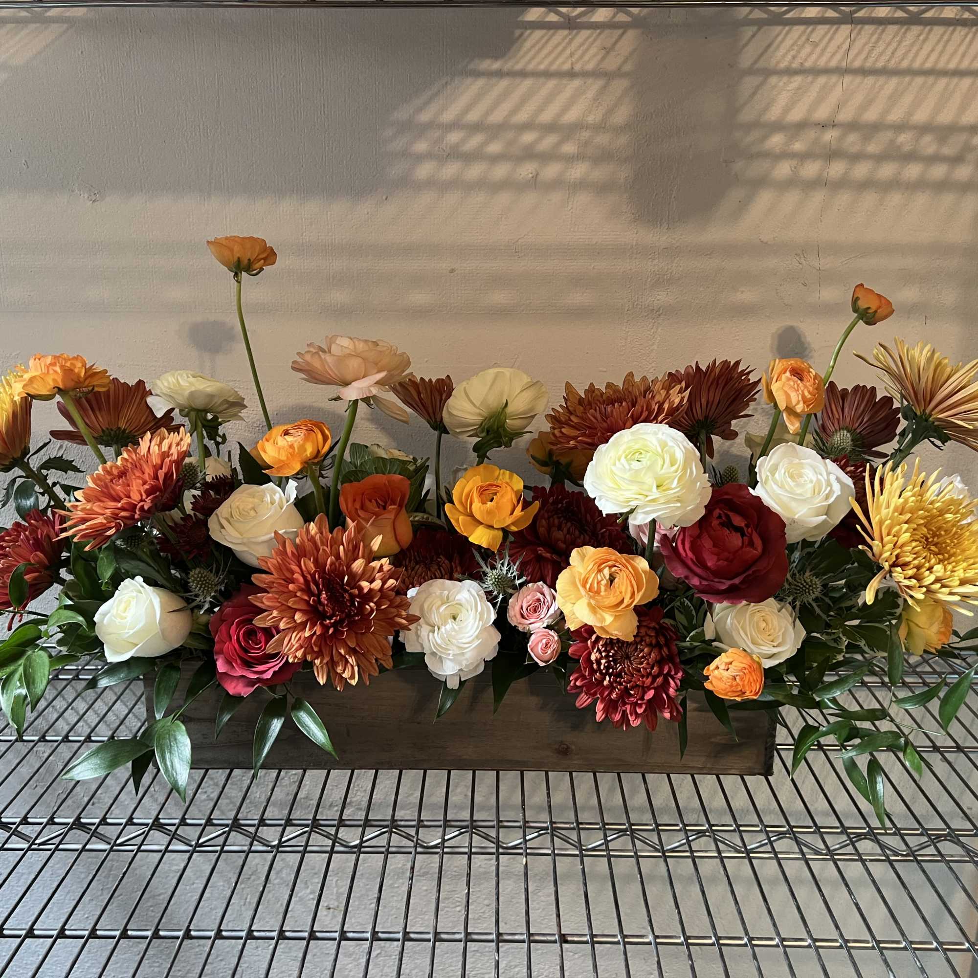 A 20&rdquo; long rectangular wooden planter. This arrangement is a stunner.