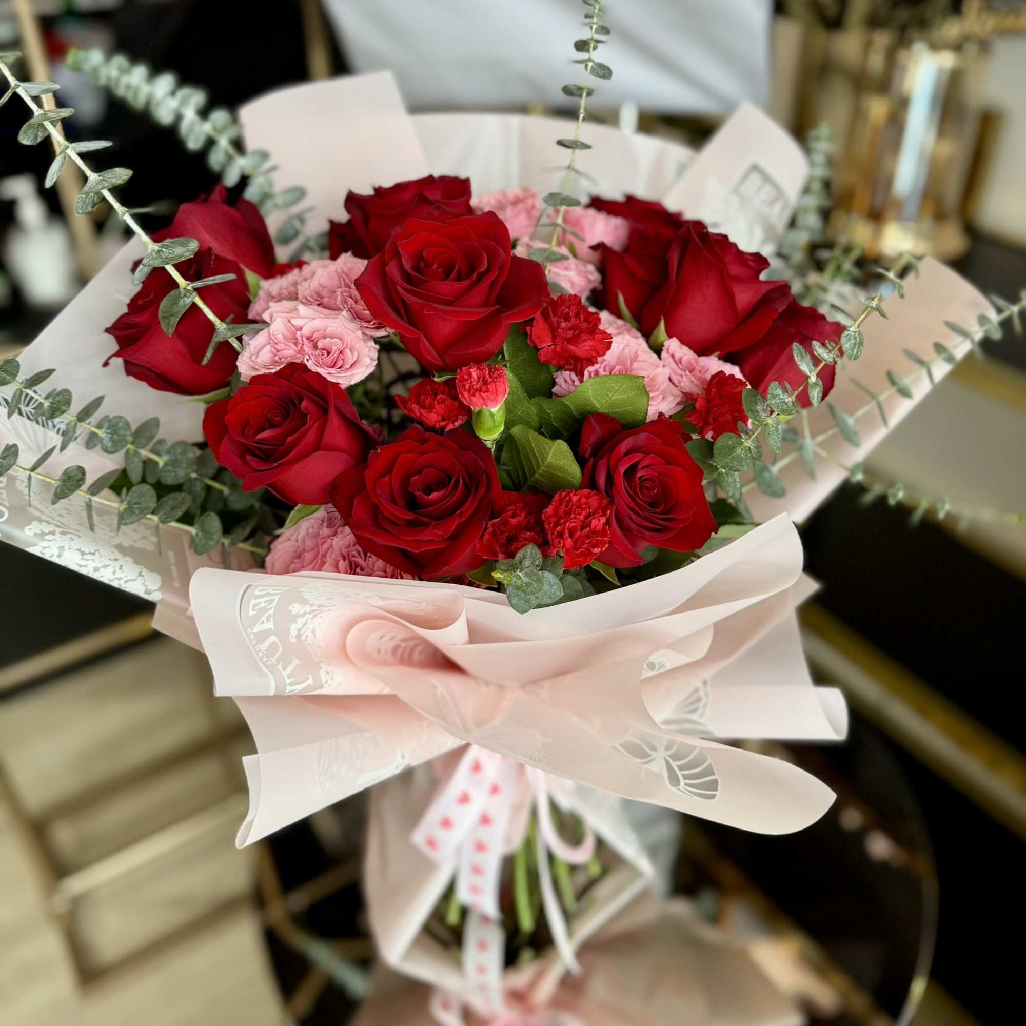 A striking blend of premium red roses and soft pink blooms, accented