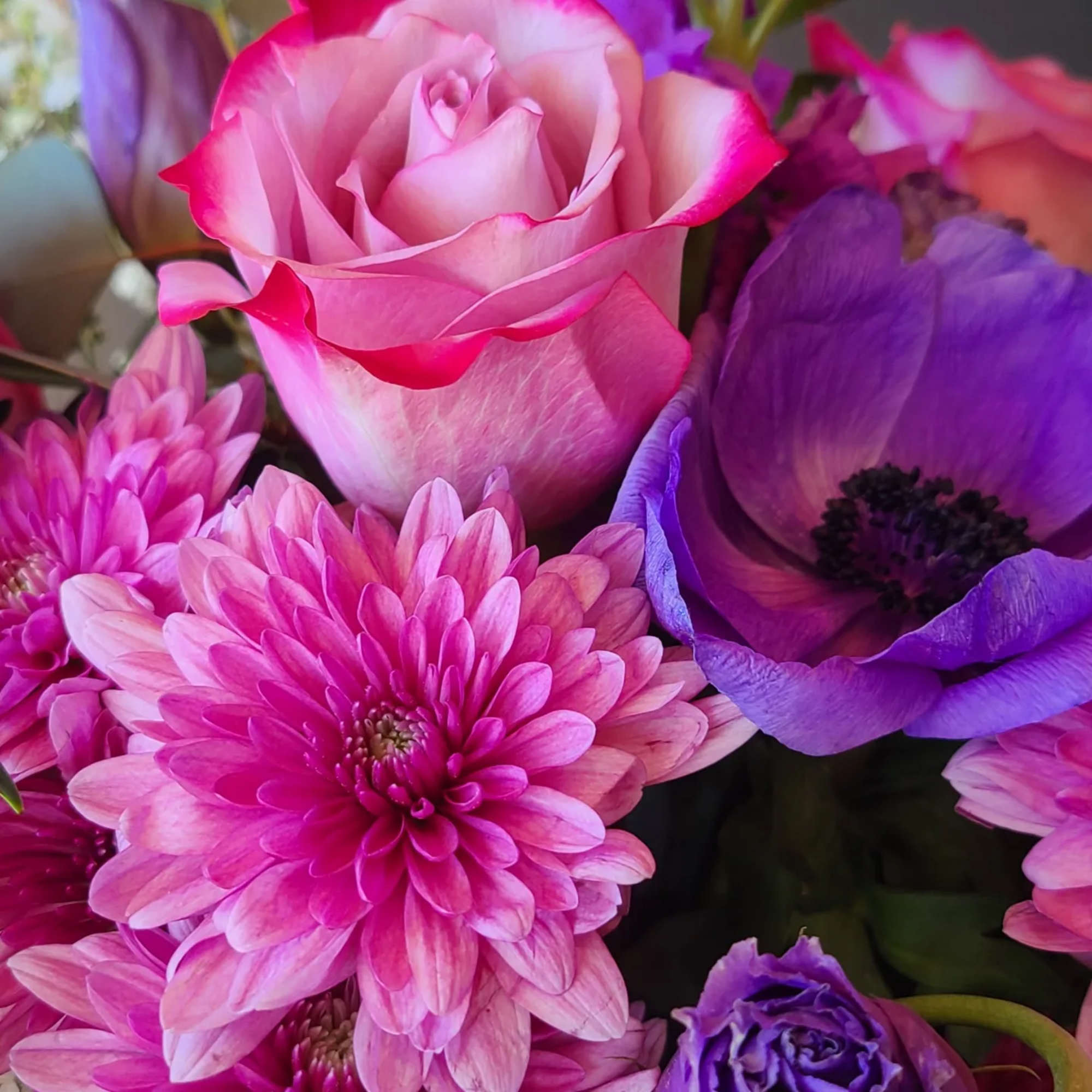 Spread the joy with this arrangement of roses, mums, anemones, and more!