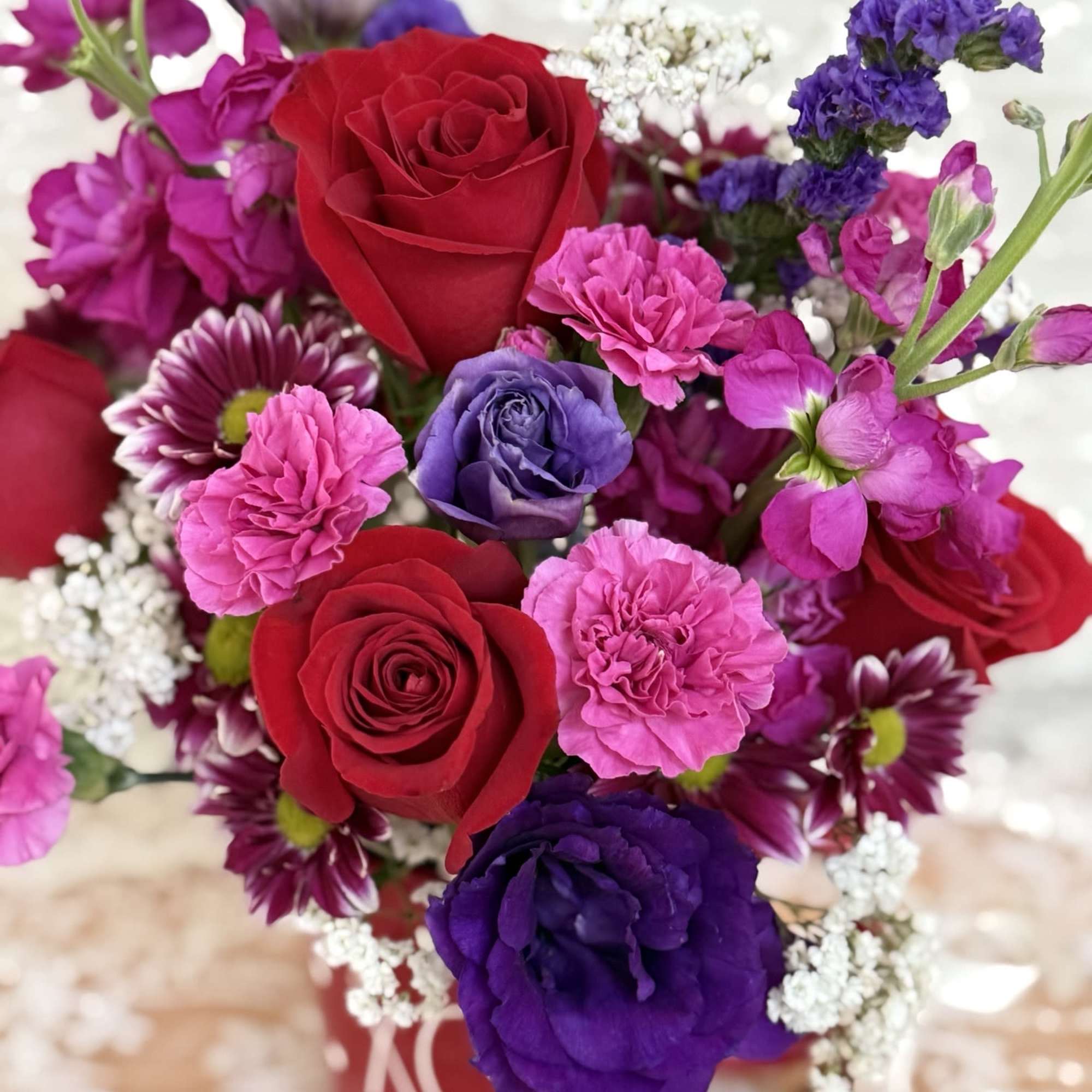 Coffee mug filled with roses, lisianthus, and spray mums.