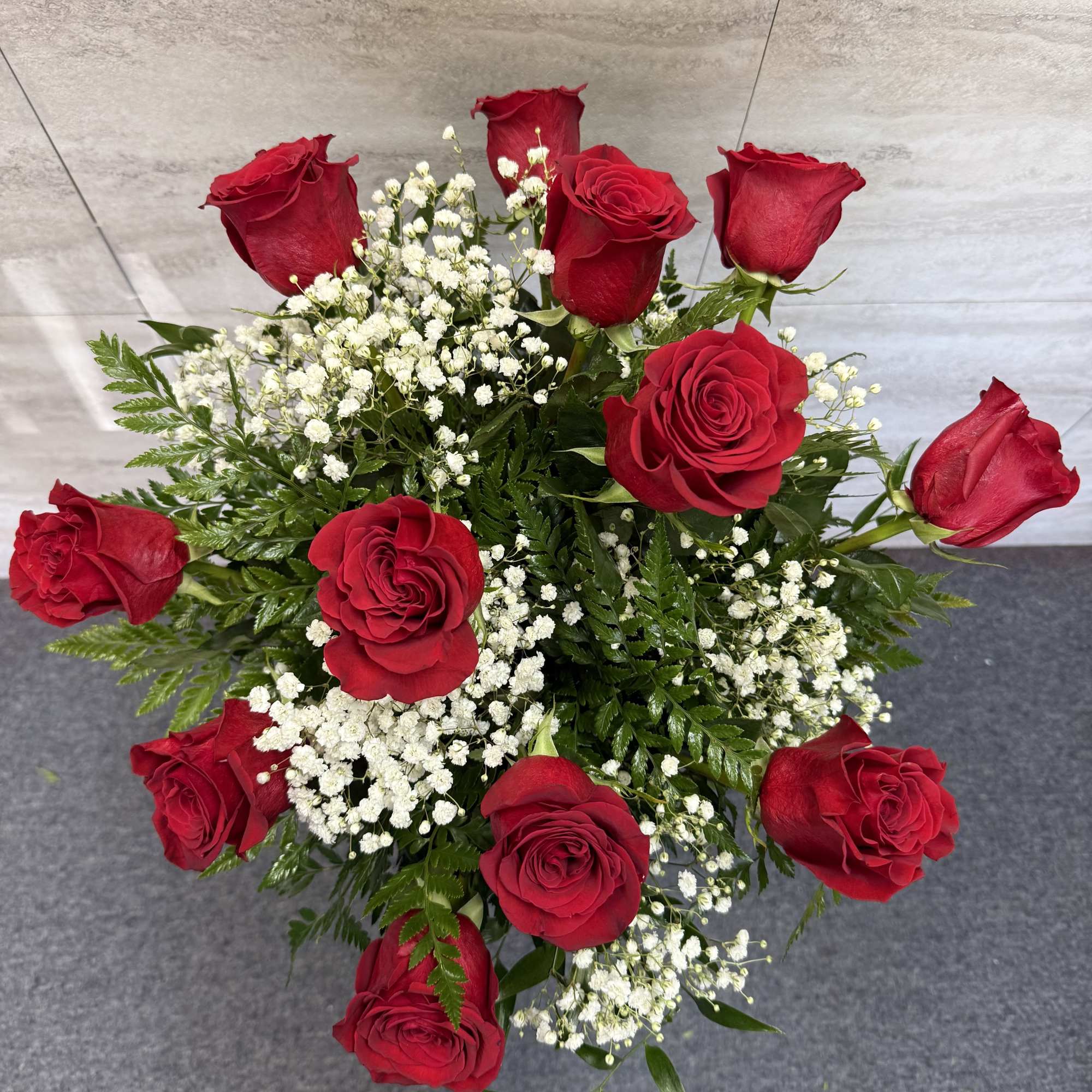 A classic arrangement of vibrant red roses accented with delicate baby&rsquo;s breath