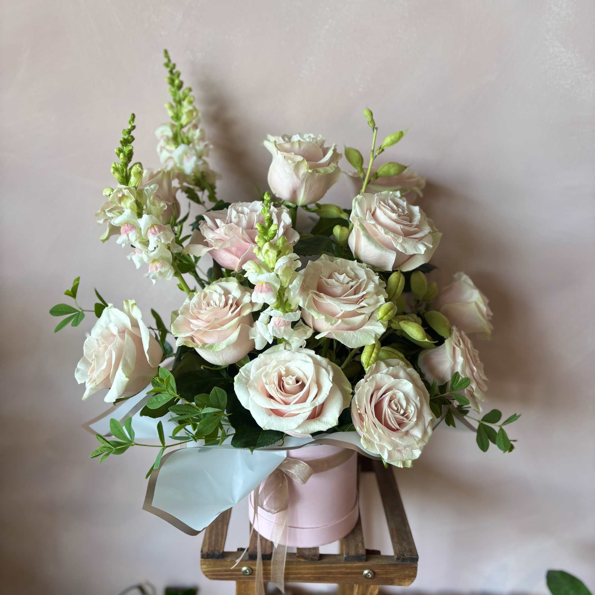 One dozen stunning roses paired with creamy complimentary blooms and lush greenery