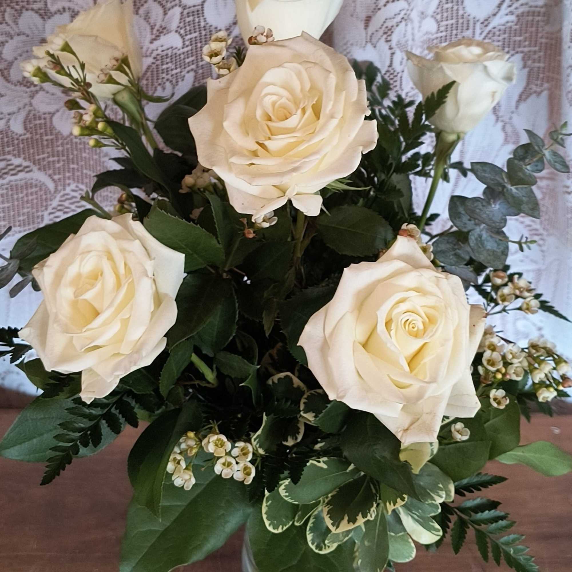 Premium white roses arranged in a glass vase. 