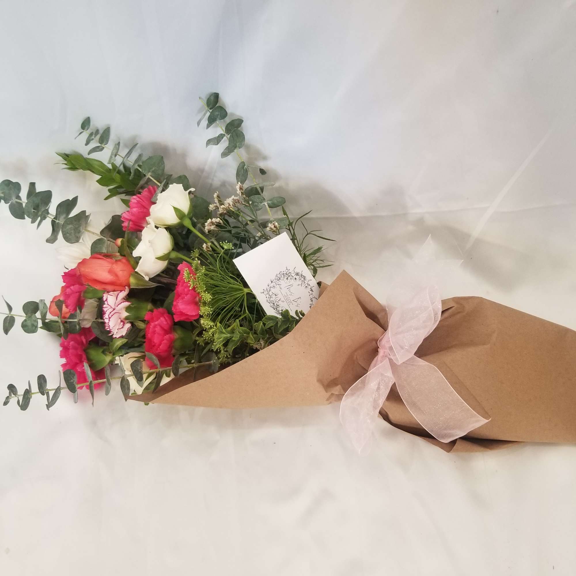 This beautiful wrapped bouquet is made with a mixture of seasonal flowers