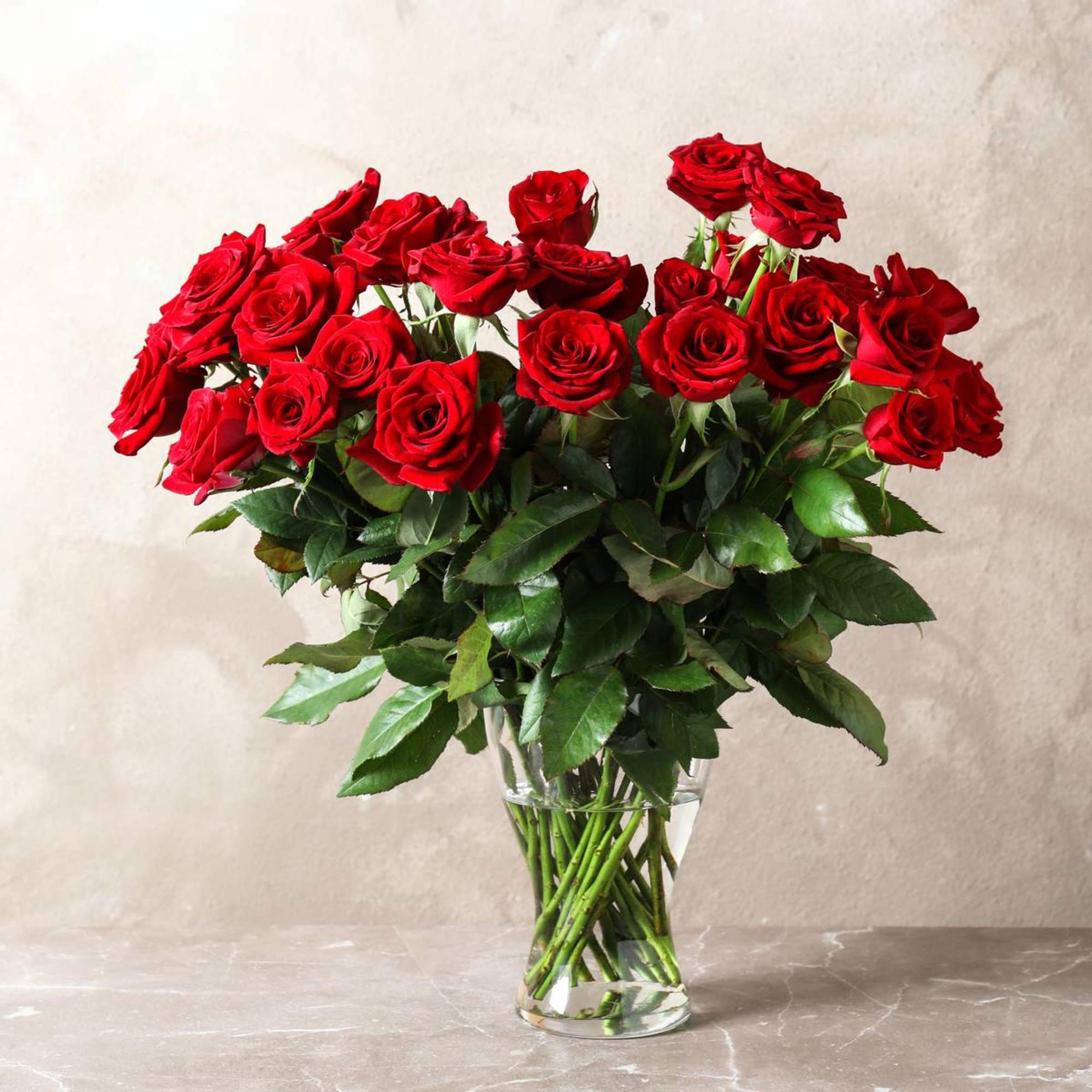 Beautiful long-stemmed red roses presented in a high quality clear glass or