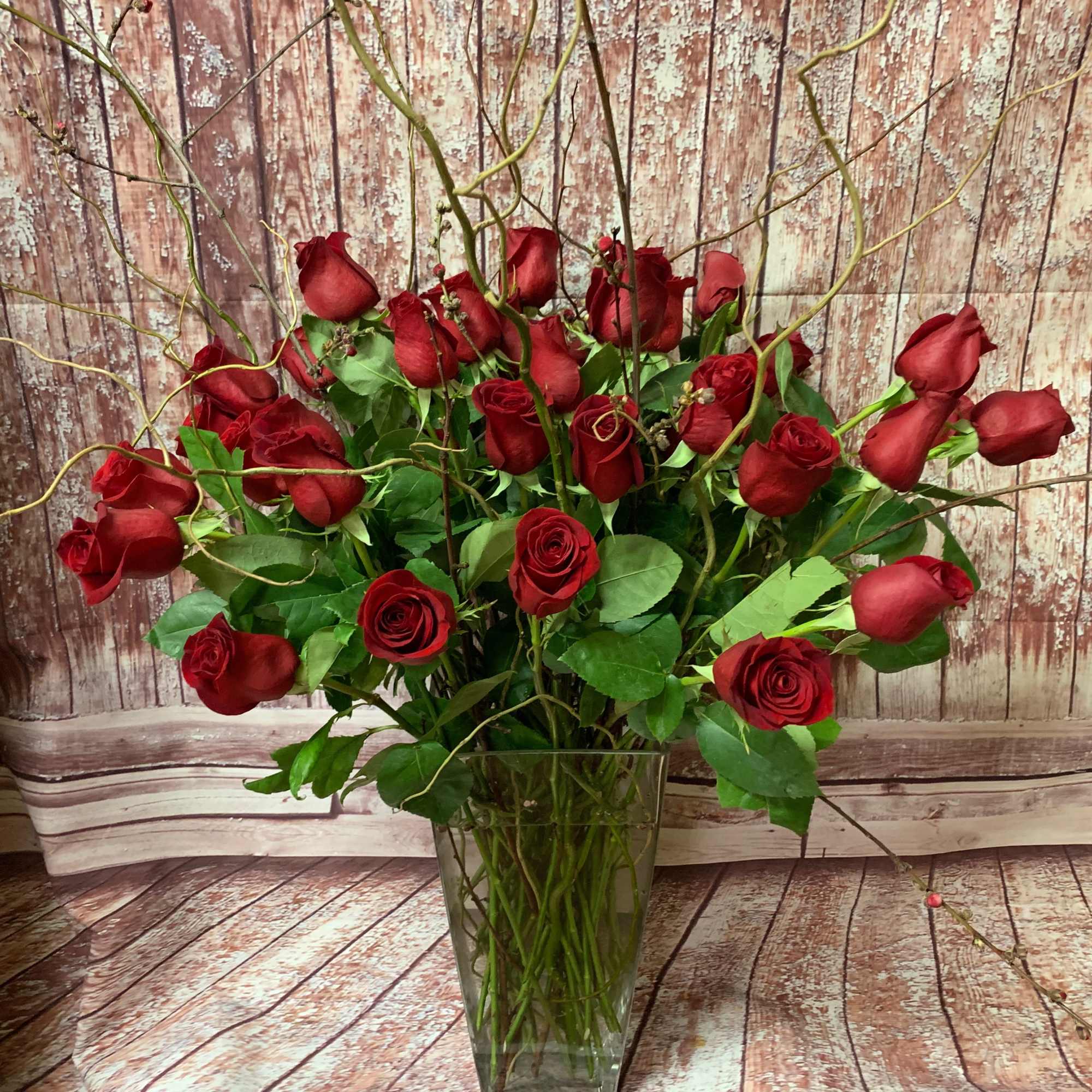 Beautiful long-stemmed red roses presented in a high quality clear glass or