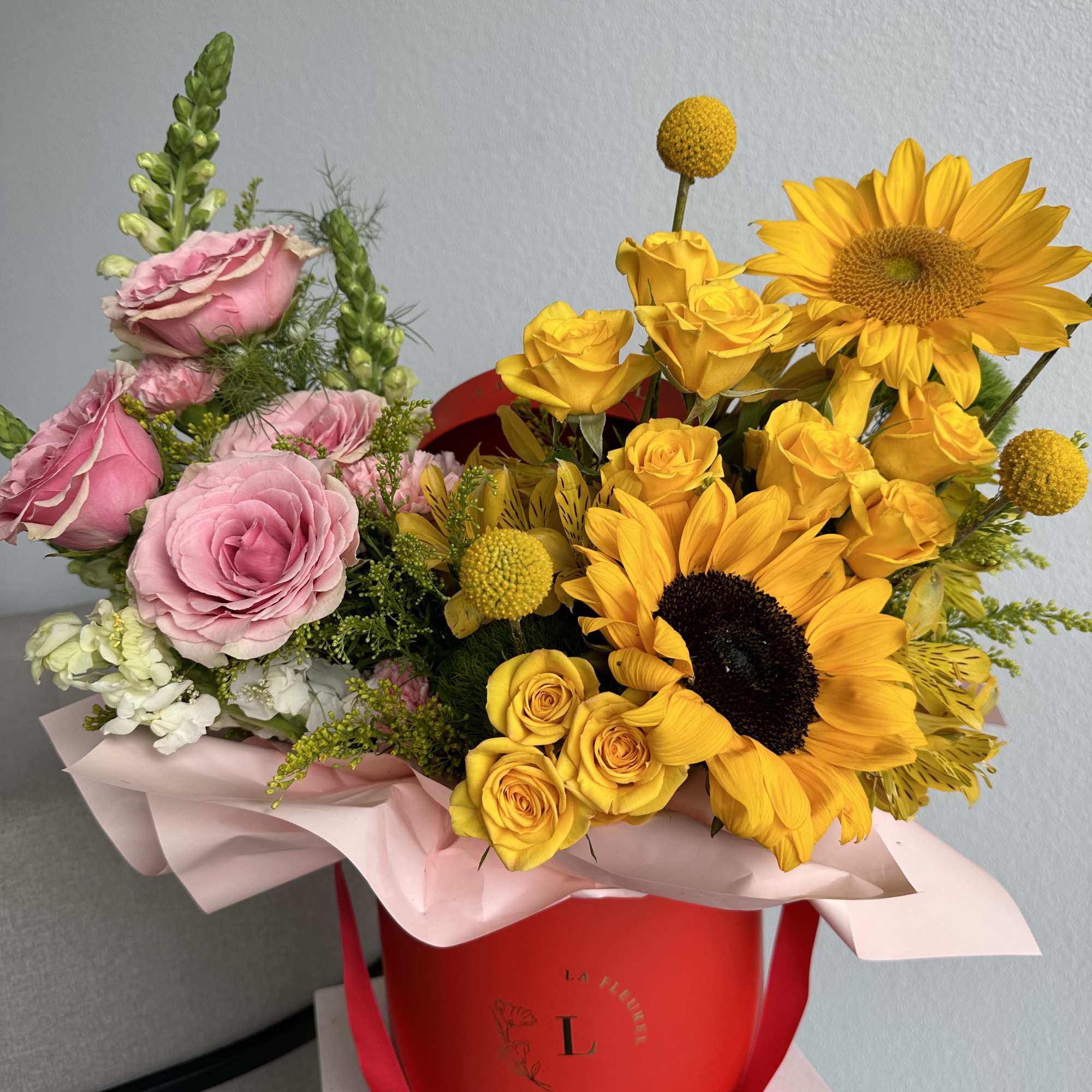 This beautiful arrangement is filled with yellow and pink roses, hydrangeas, sunflowers