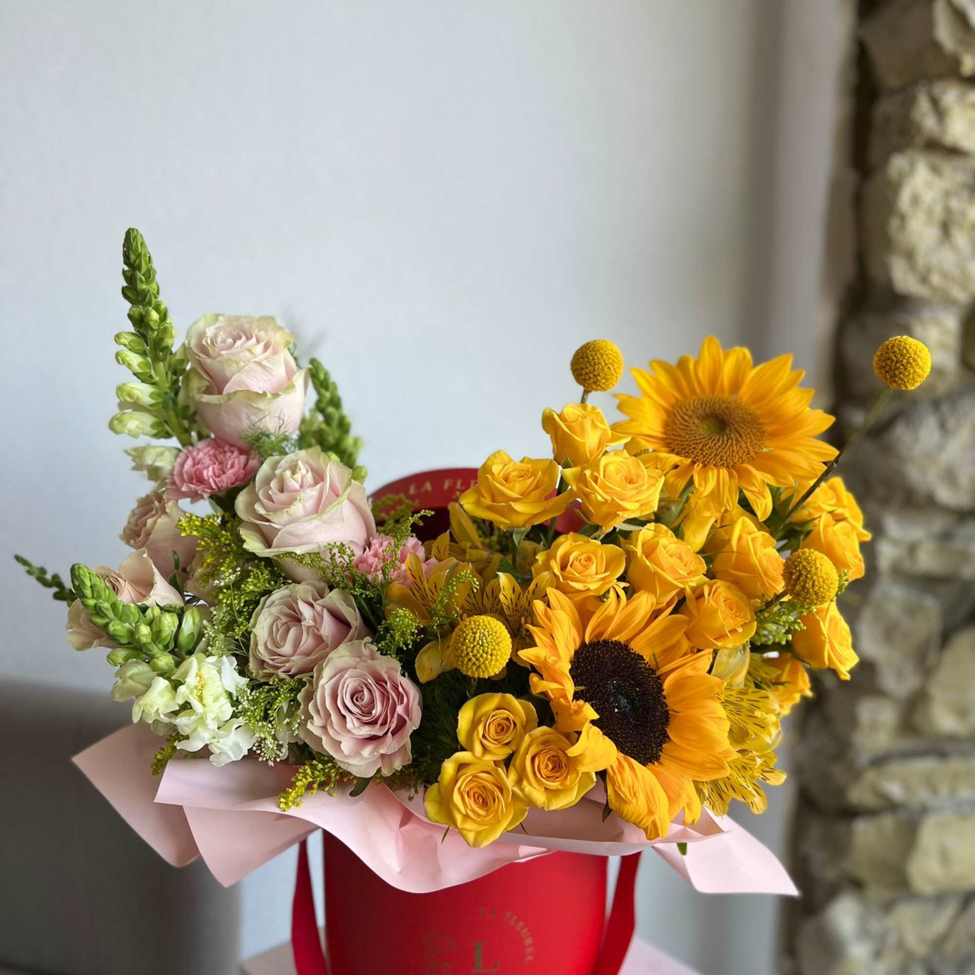 This beautiful arrangement is filled with yellow and pink roses, hydrangeas, sunflowers