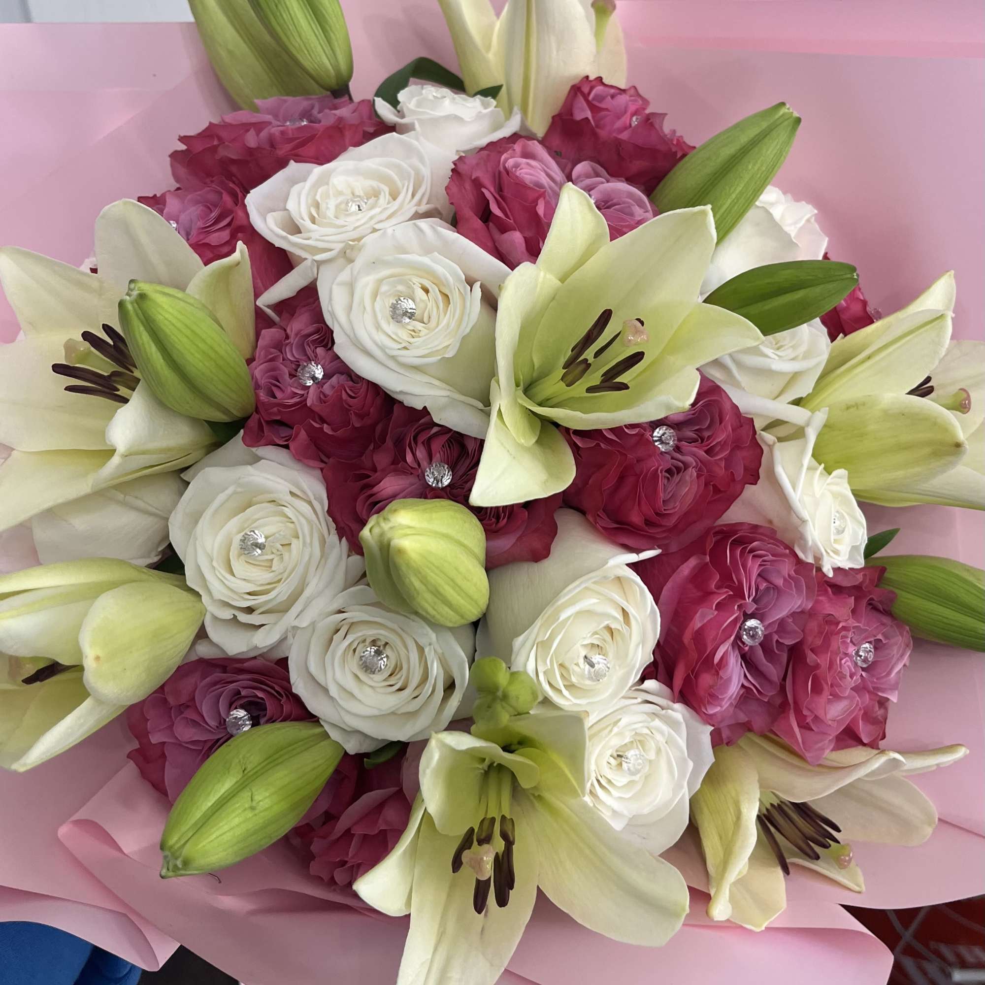 Two dozen roses with lilies wrapped with a large bow, Crown and