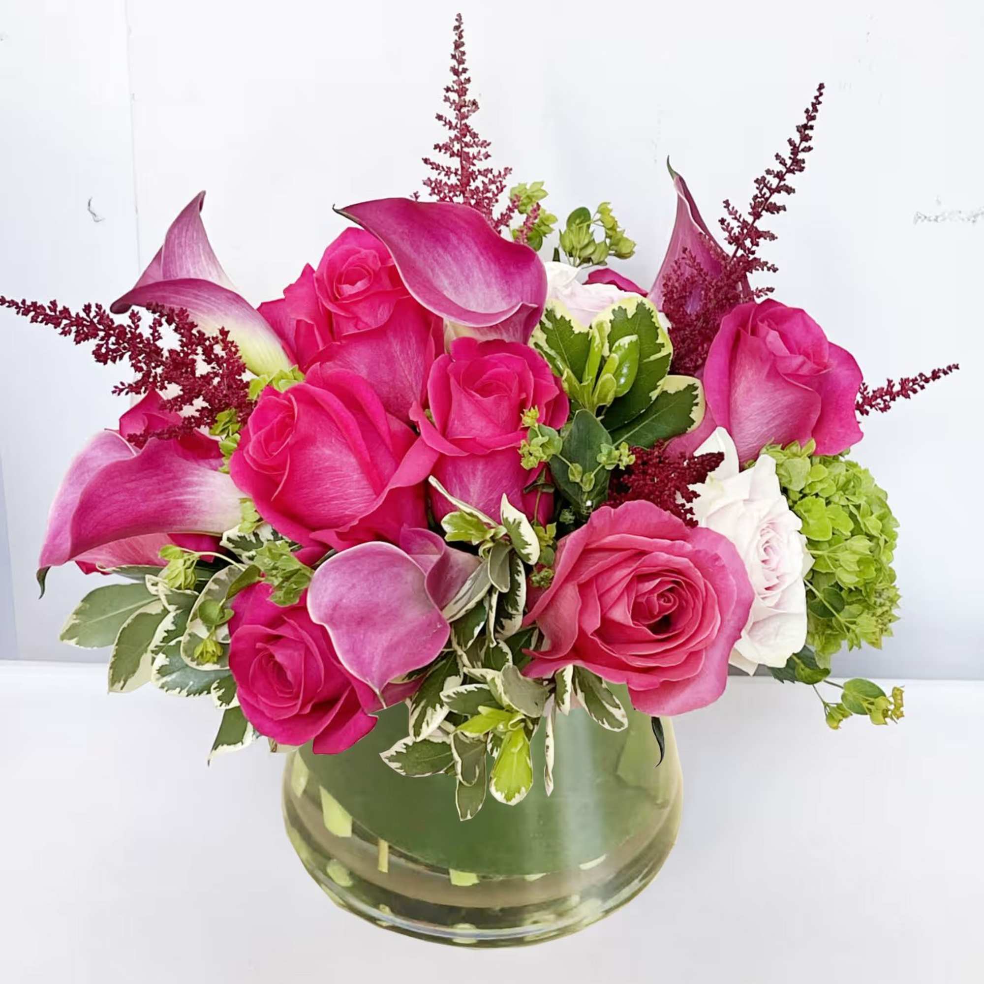 This pink arrangement features hot pink and pastel pink roses, accented with