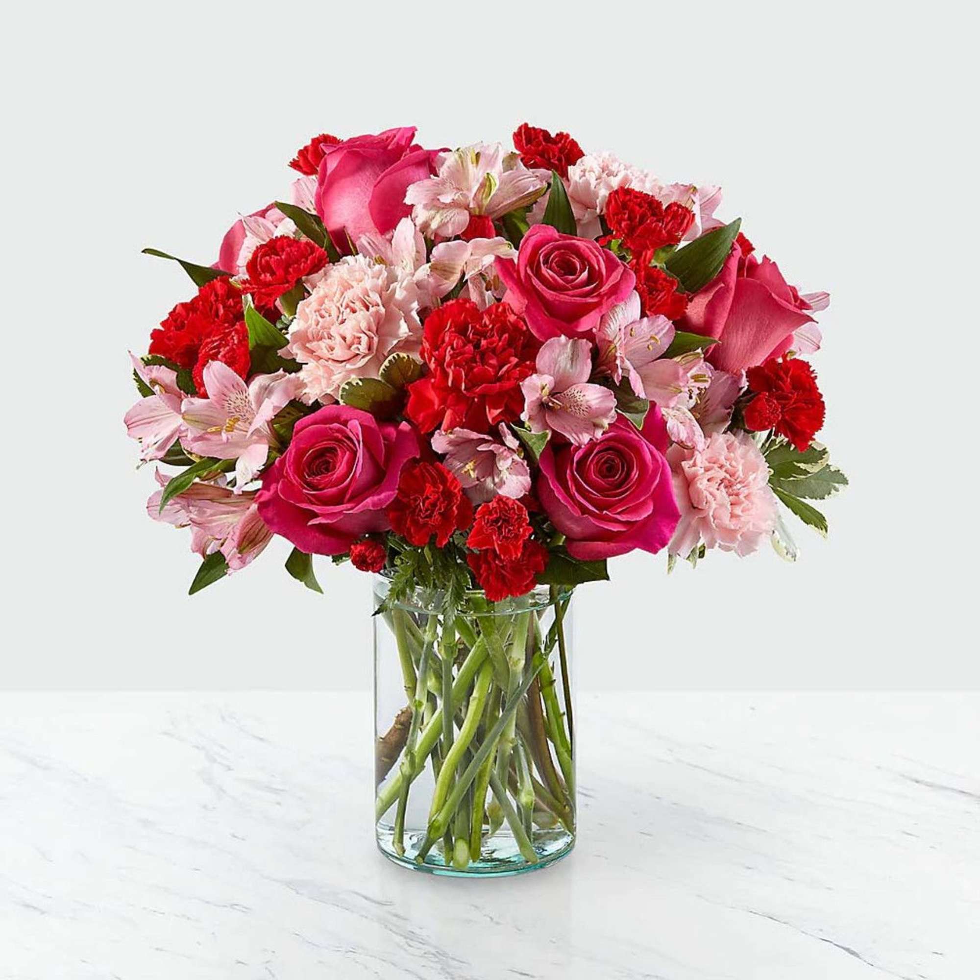 Blushing shades of pink blooms are nestled in lush greens to charm