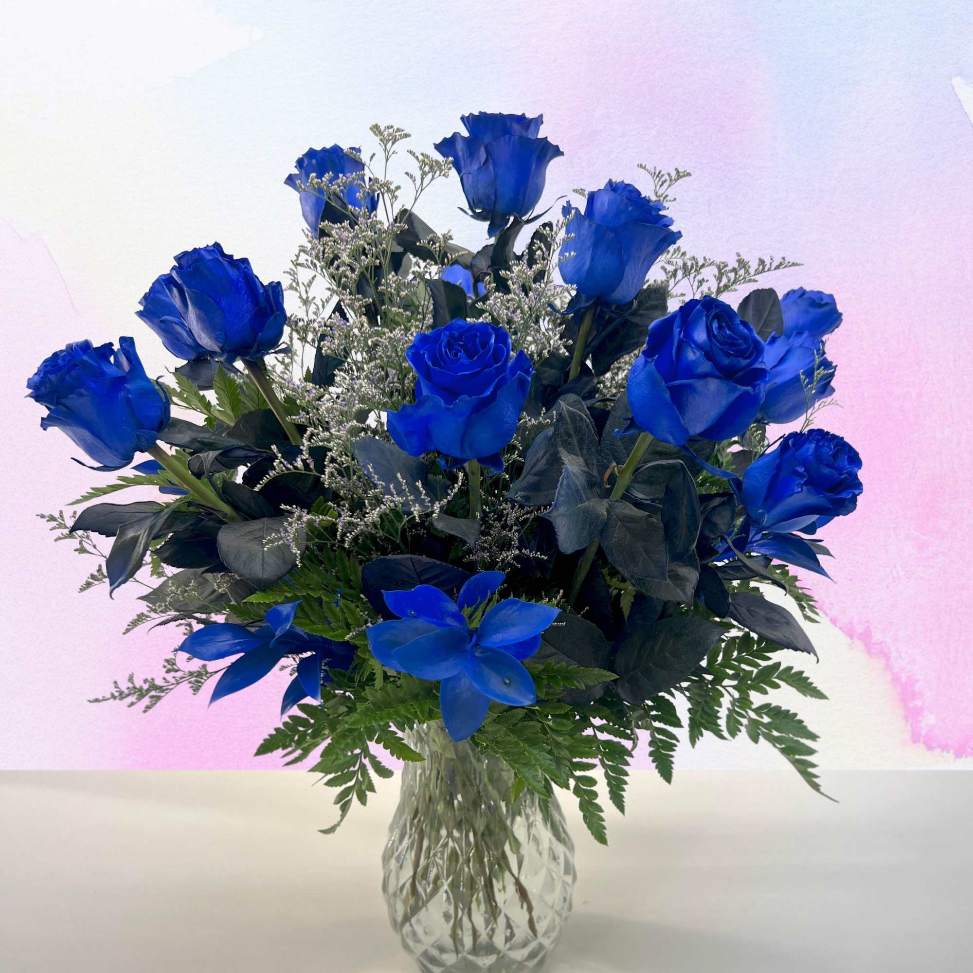 12 Long stem blue roses beautifully arranged in a blue vase. 