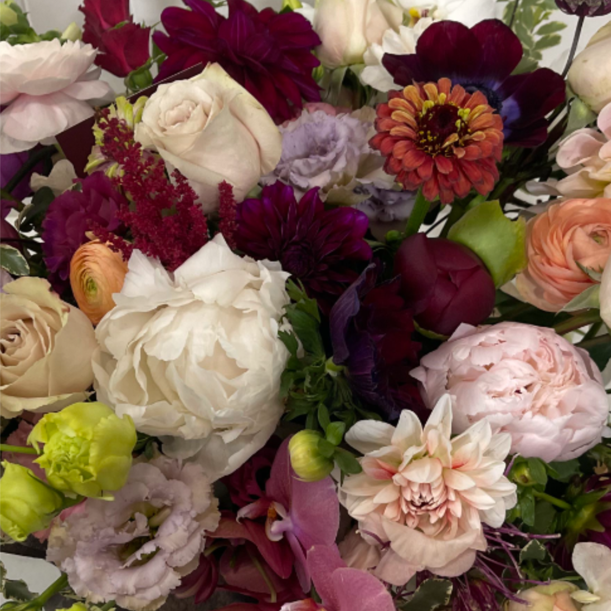 Floral arrangement in seasonal autumn hues - peach, orange, yellow, fuchsia, magenta